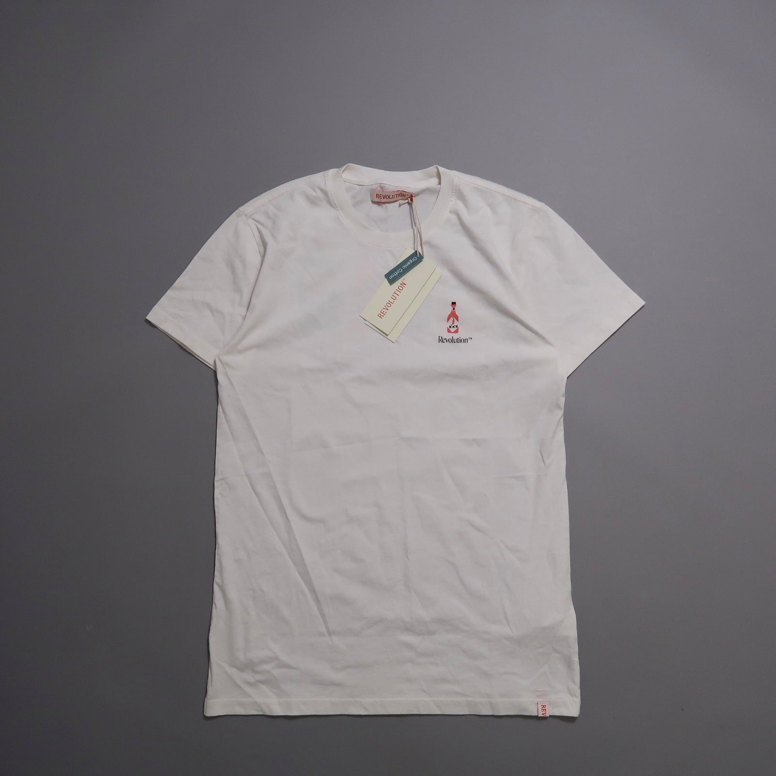 White T-shirt with a small logo and tags on a gray background.