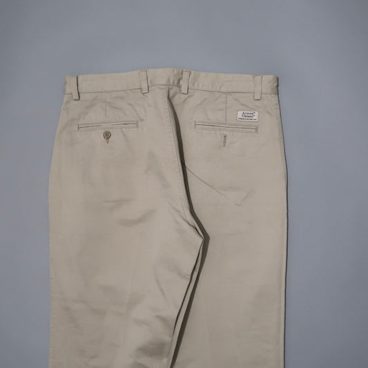 Beige khaki pants with rear pockets and a small label.
