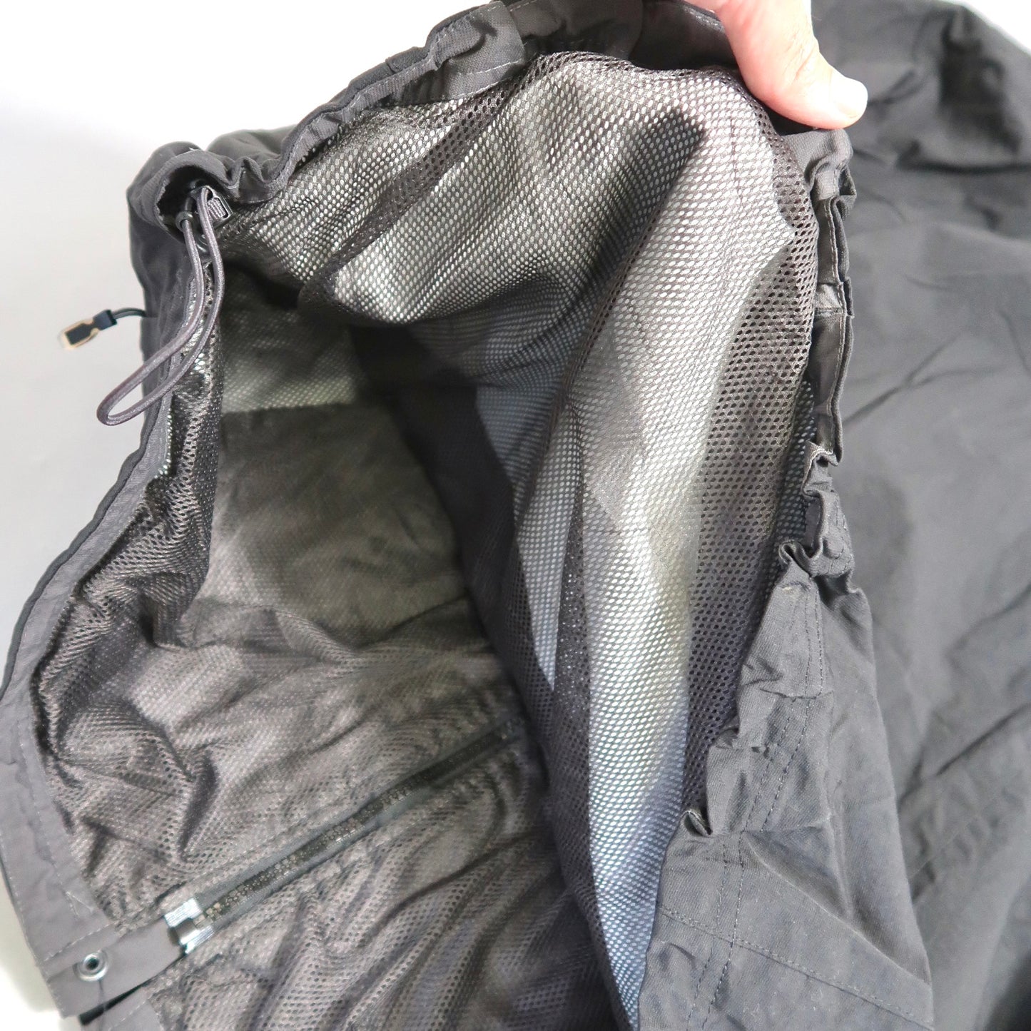 Close-up of a black jacket with grey mesh lining.
