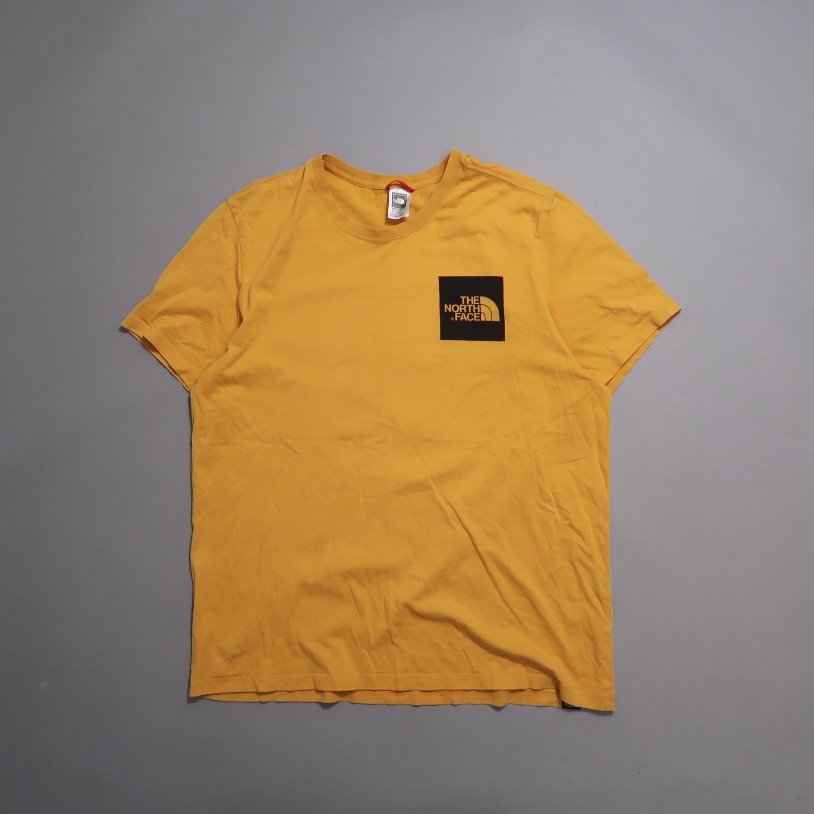 Yellow T-shirt with black nullThe North Facenull logo on front.
