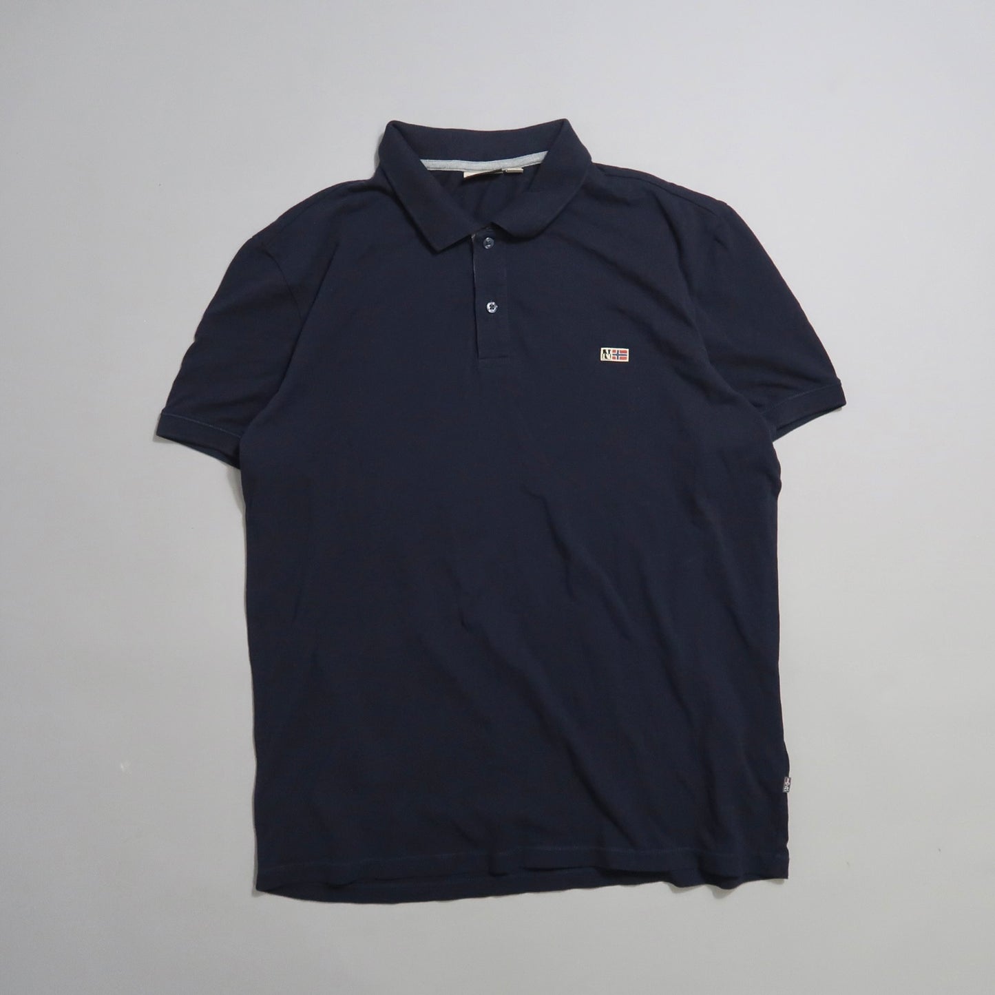 Navy blue polo shirt with buttoned collar on a plain background.