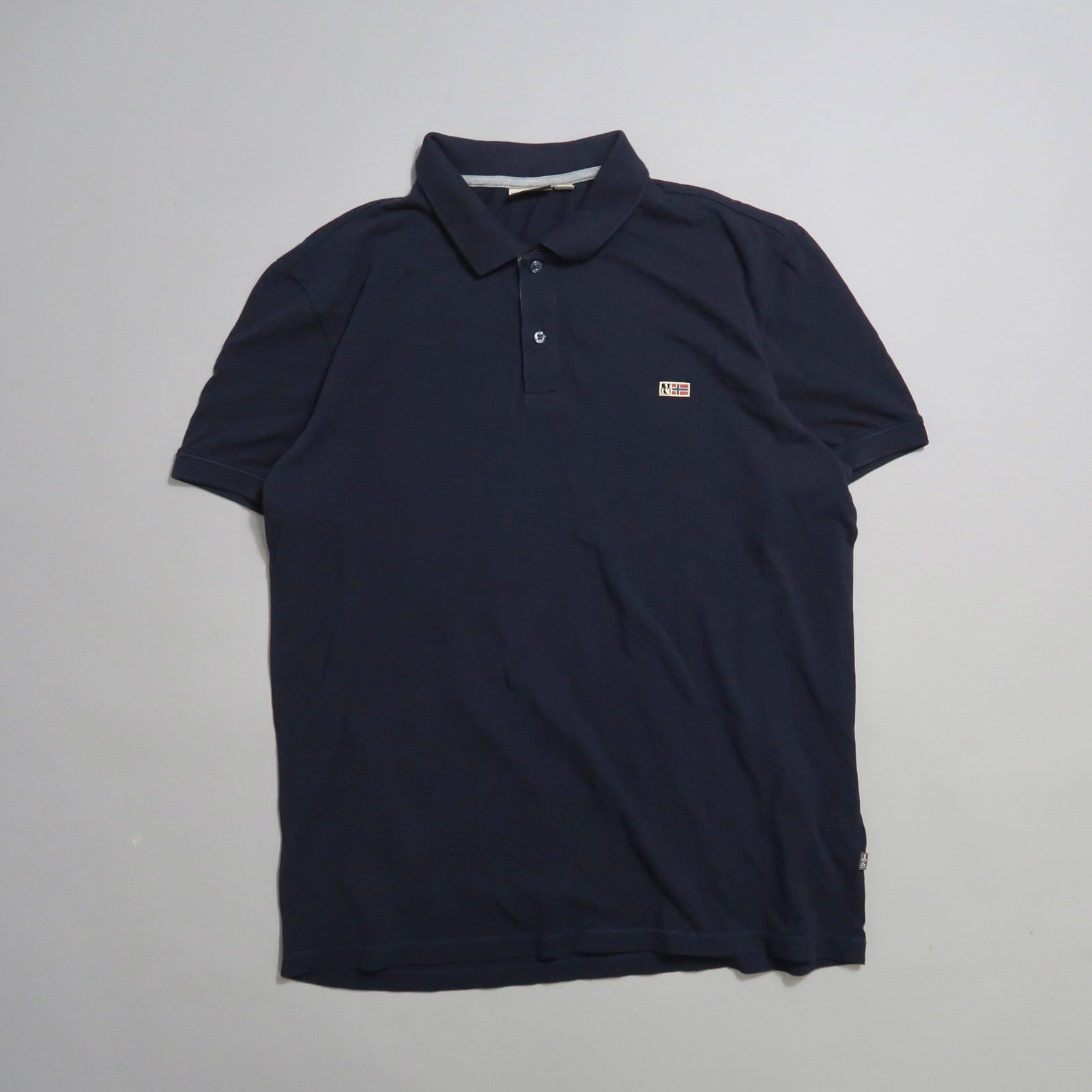 Navy blue polo shirt with buttoned collar on a plain background.