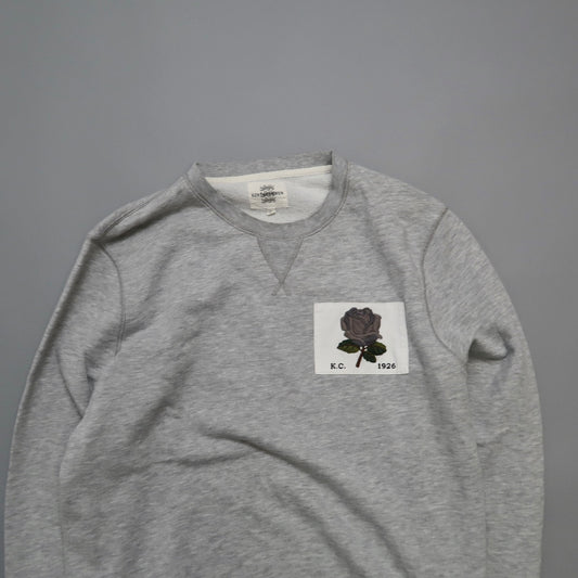 Gray sweatshirt with black rose patch labeled nullK.C. 1926null.