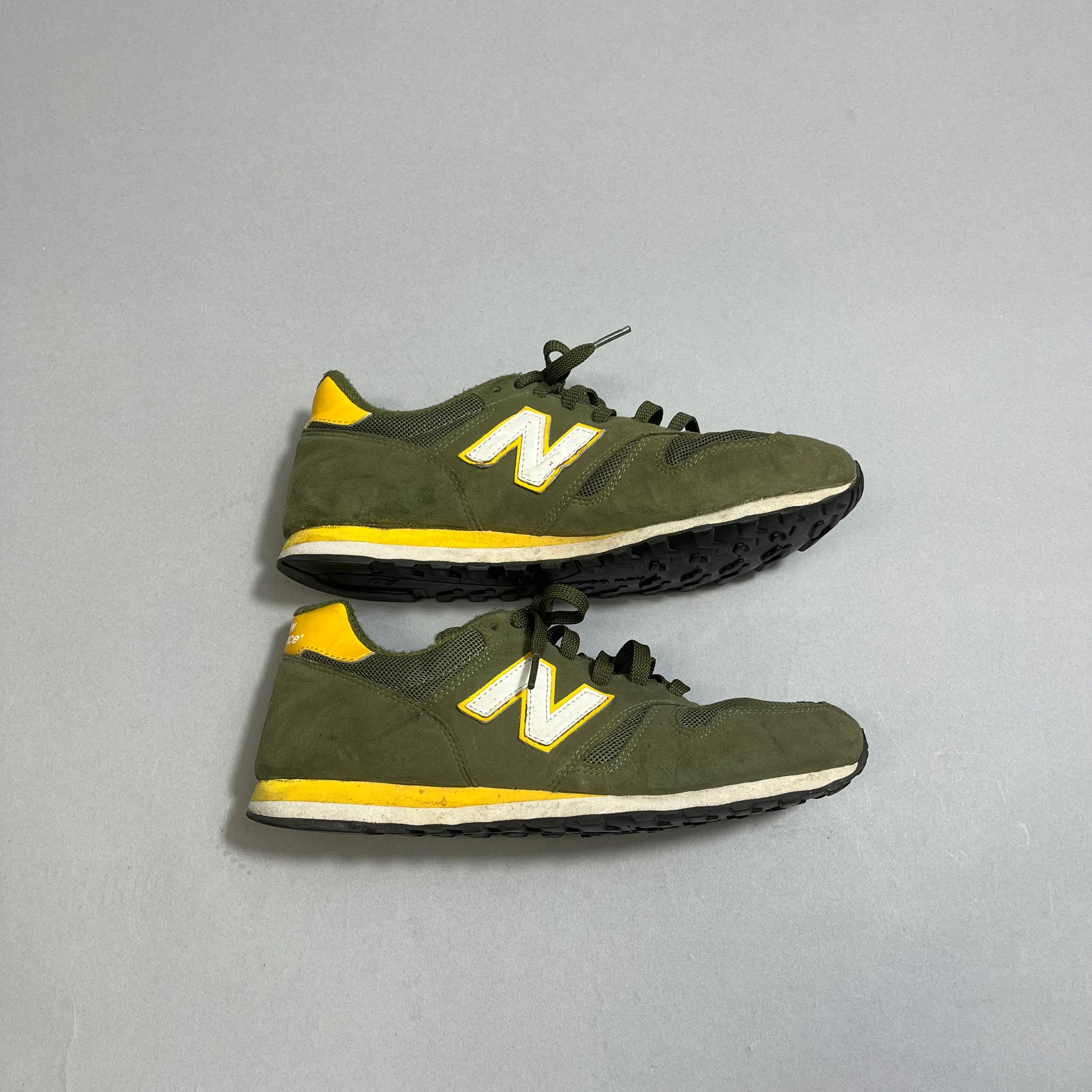 Pair of green and yellow sneakers with a white nullNnull logo on the side.