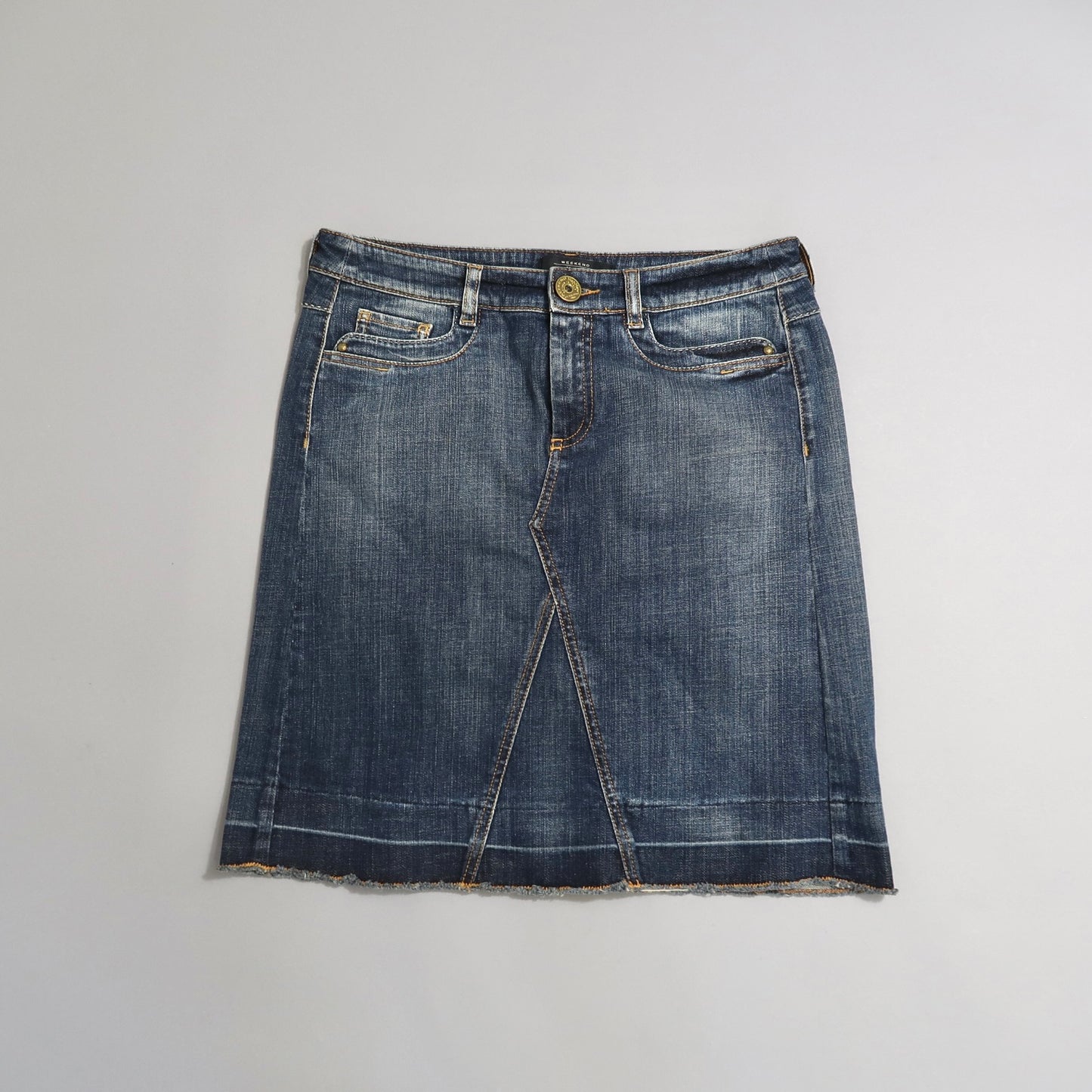 Denim skirt with pockets and button, laid flat on a white surface.