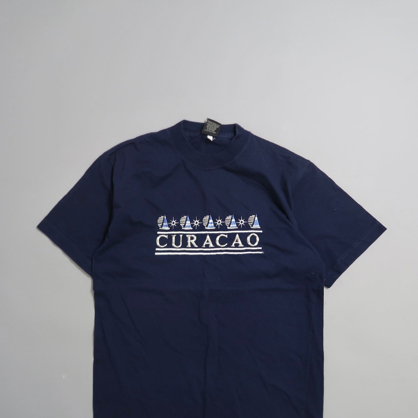 Navy blue T-shirt with nullCuracaonull and sailboat graphics.
