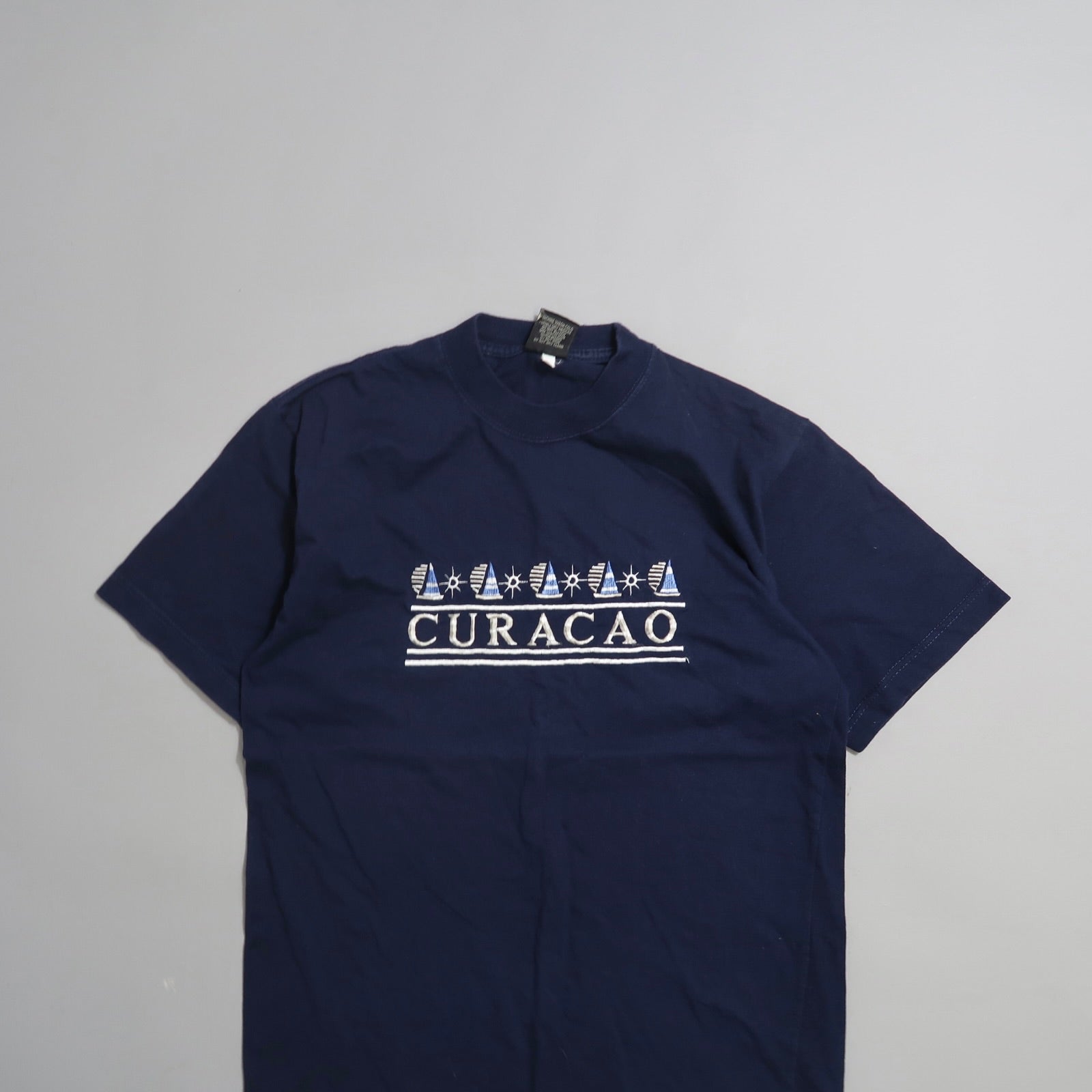 Navy blue T-shirt with nullCuracaonull and sailboat graphics.