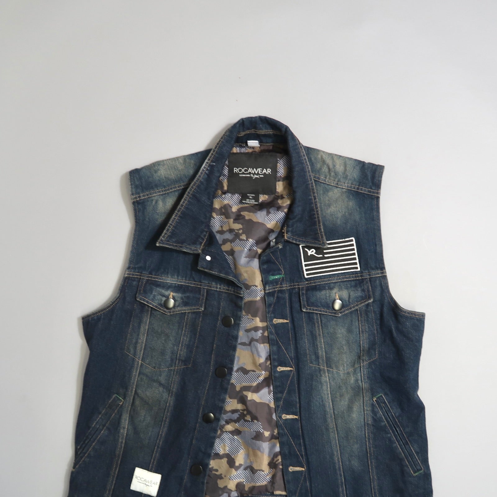 Denim vest with camo lining and patch detail on the front.