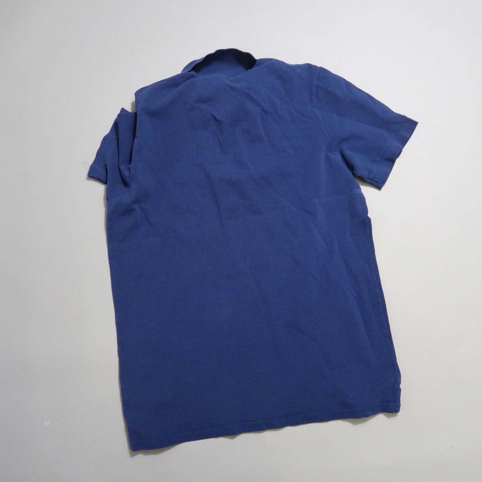 Blue T-shirt laid flat on a white background.