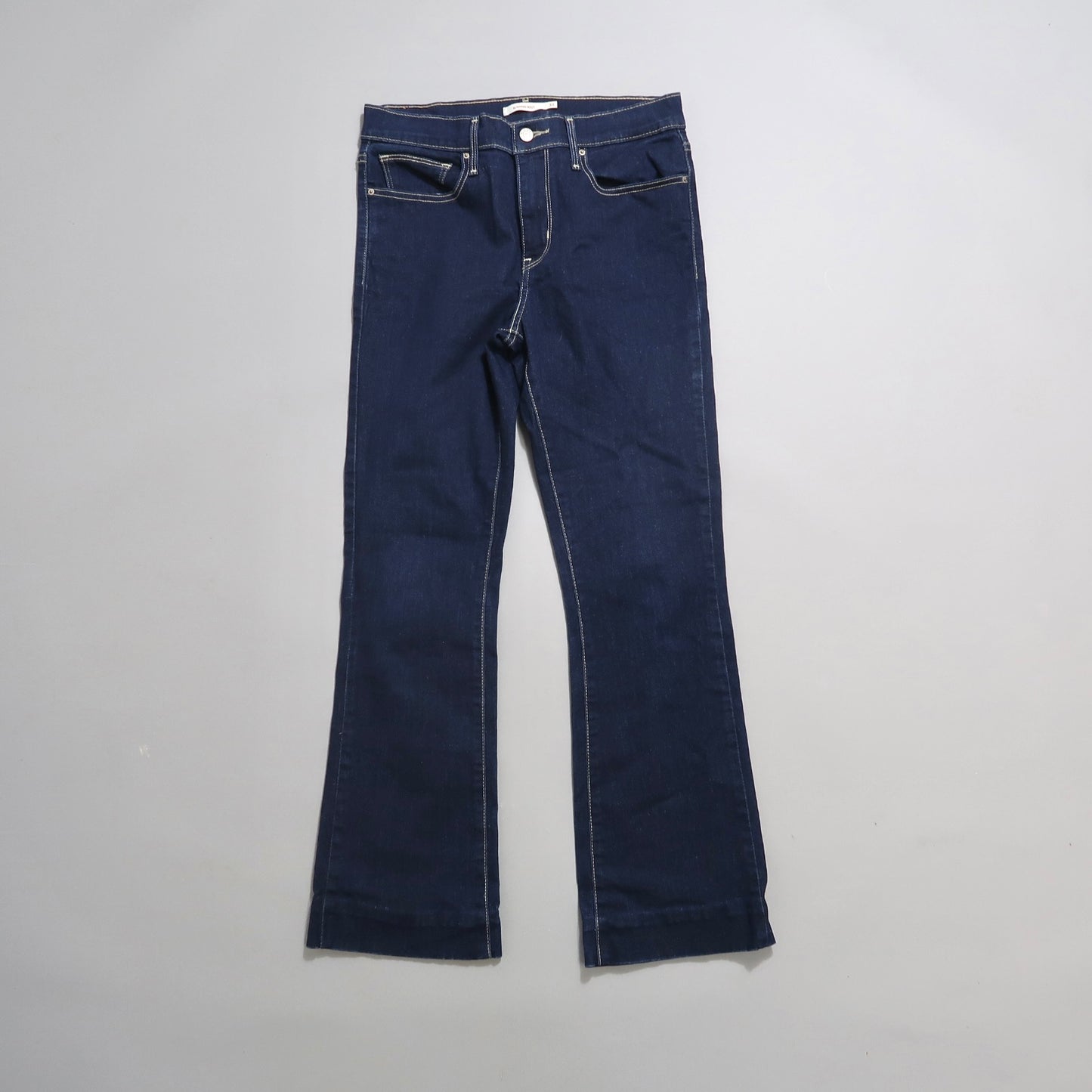 Dark blue flared jeans on a neutral background.