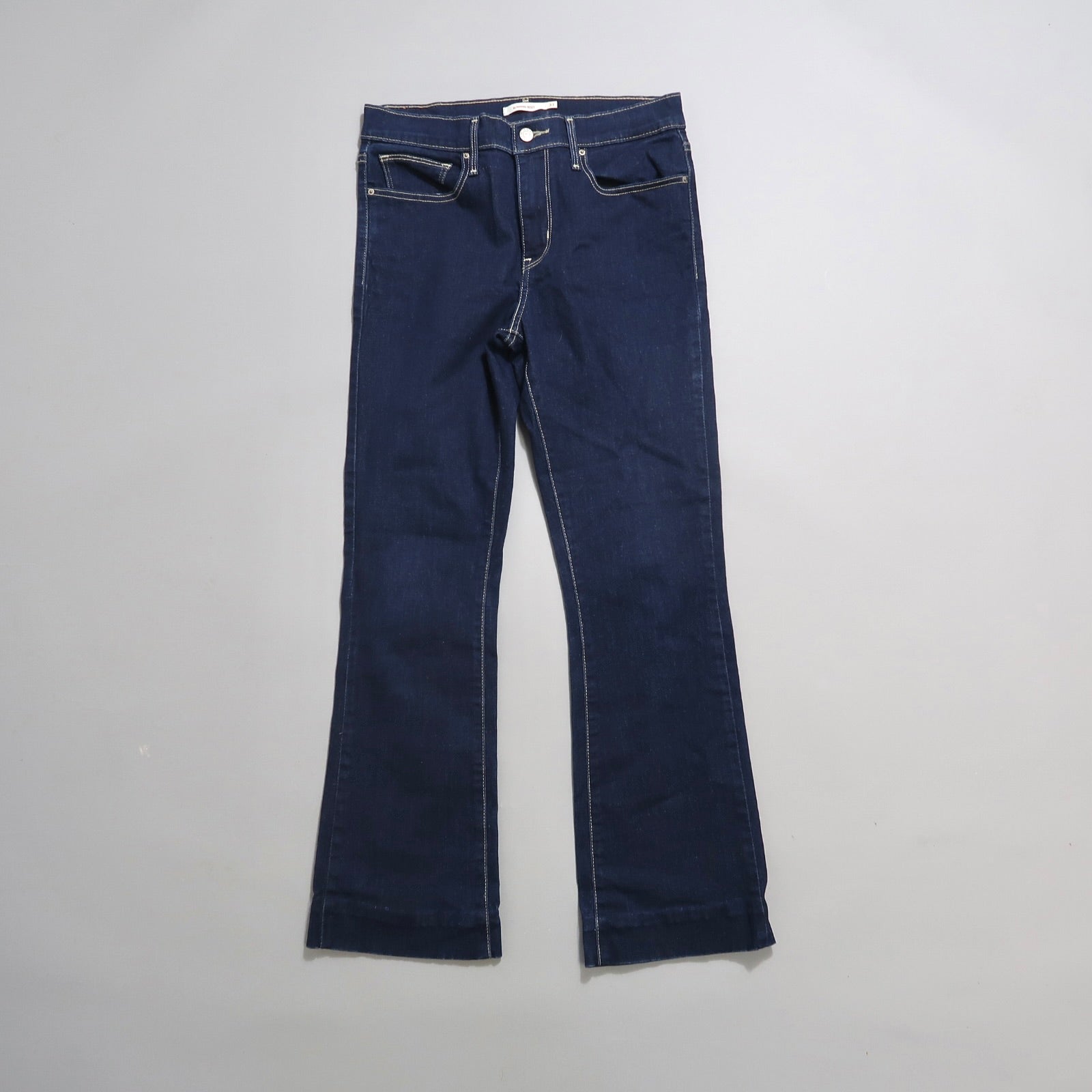 Dark blue flared jeans on a neutral background.