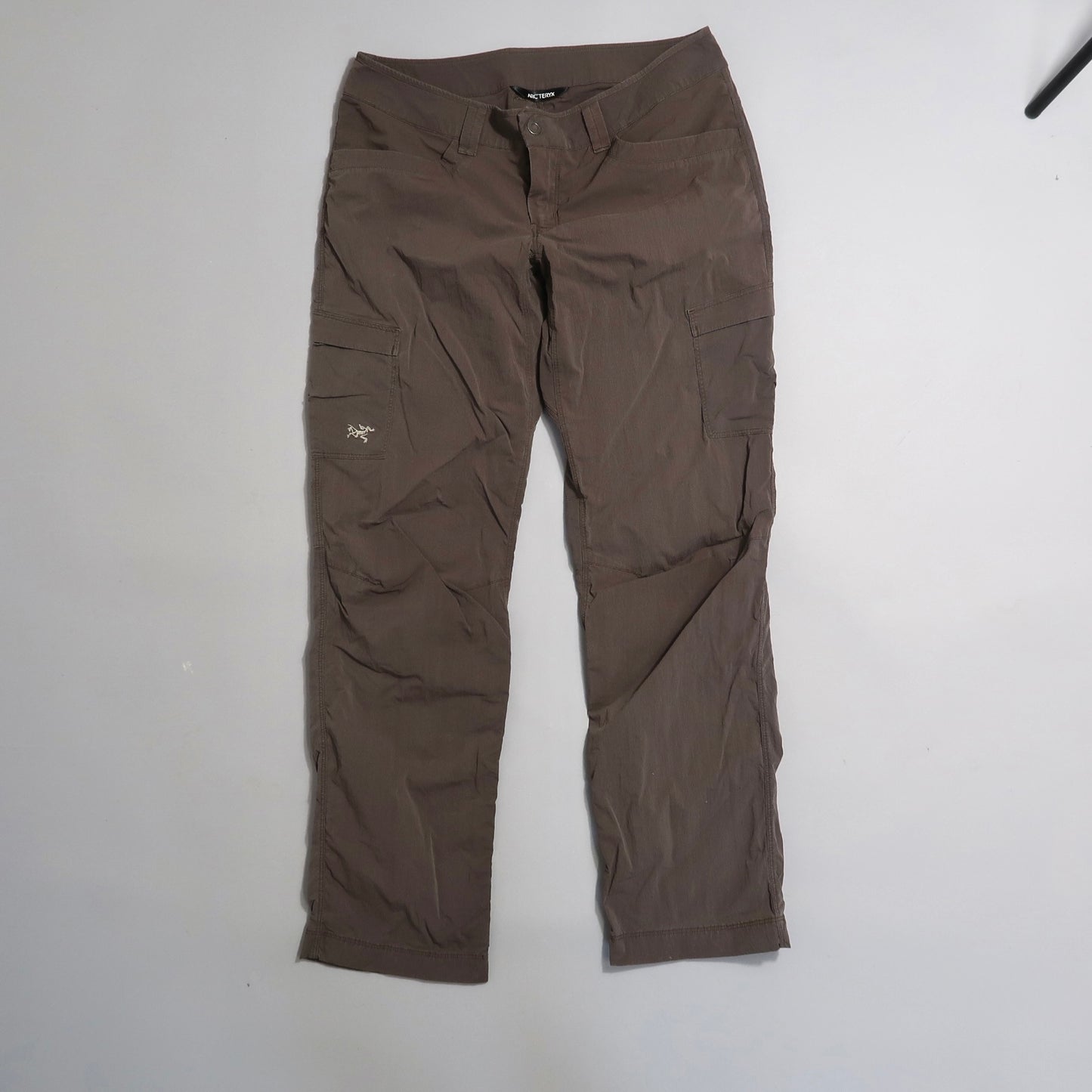 Brown cargo pants with pockets on a light background.
