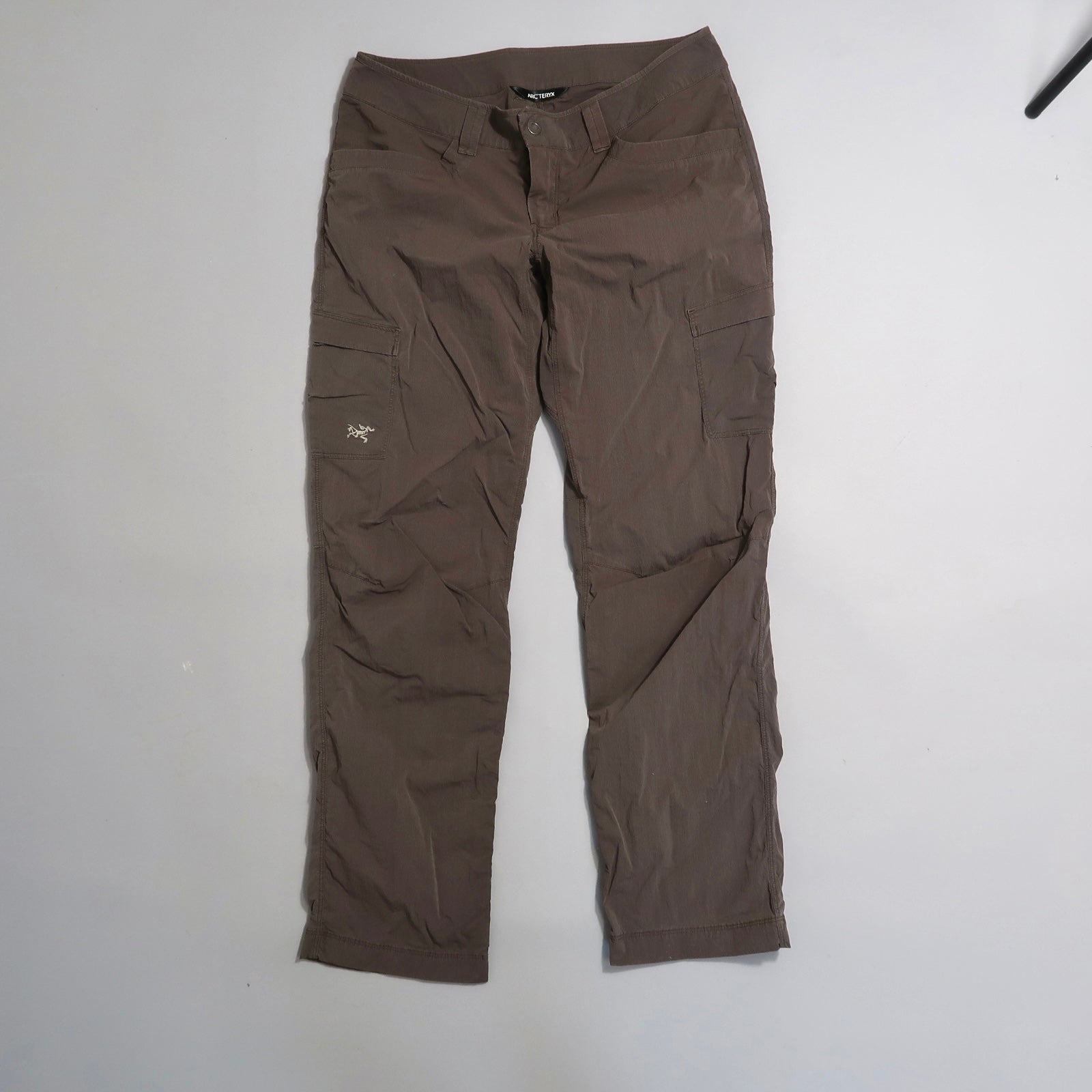 Brown cargo pants with pockets on a light background.