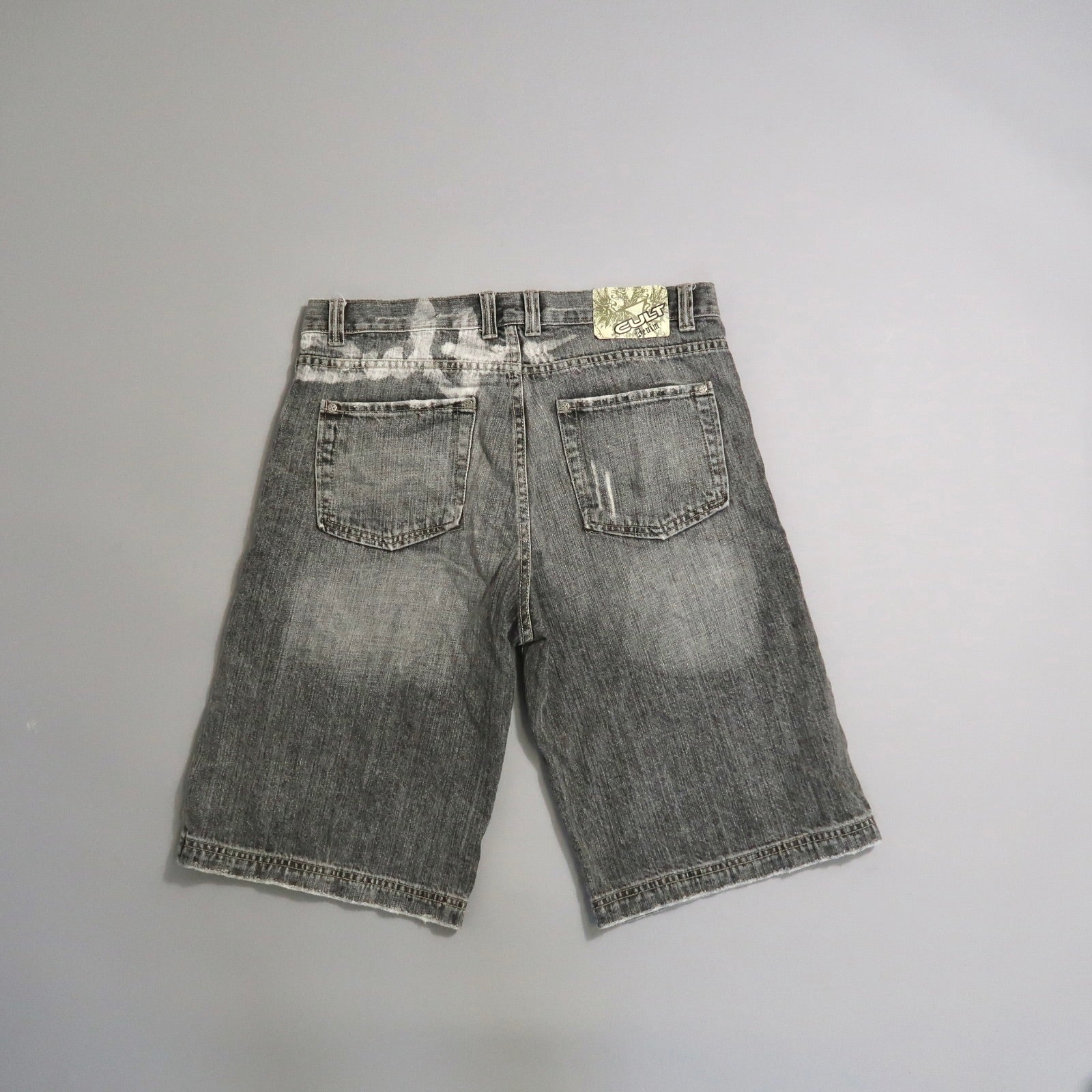 Gray denim shorts on a flat gray background.