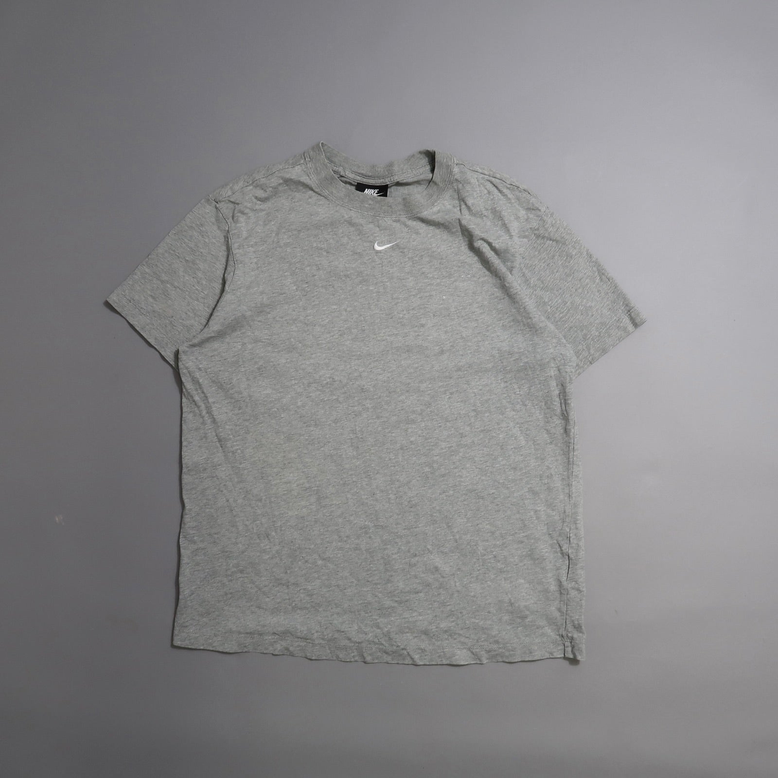 Gray Nike T-shirt on a neutral background.