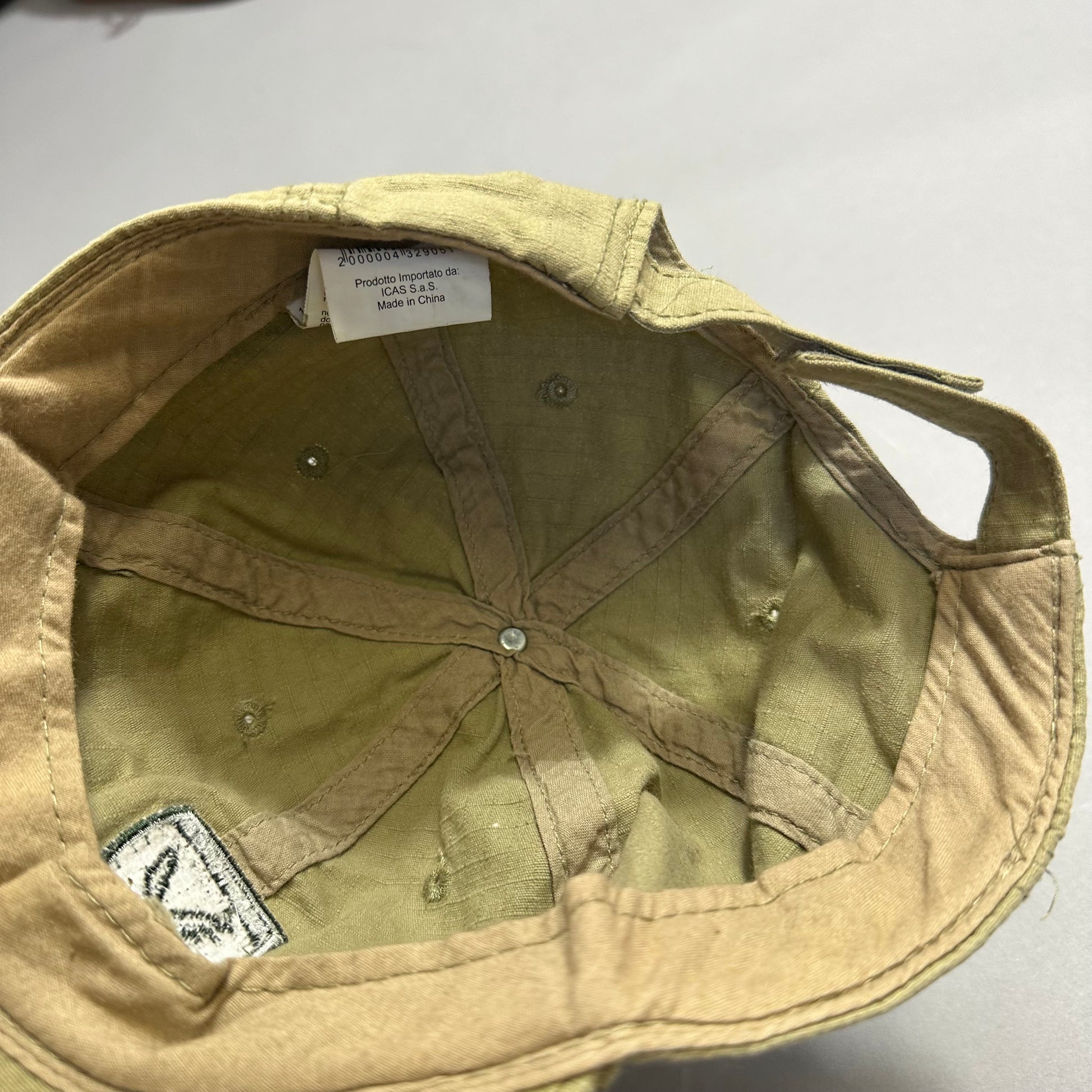 Inside view of a beige bucket hat with a small tag.
