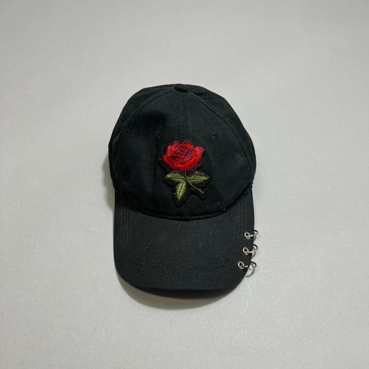 Black cap with red rose embroidery and metal rings on the brim.