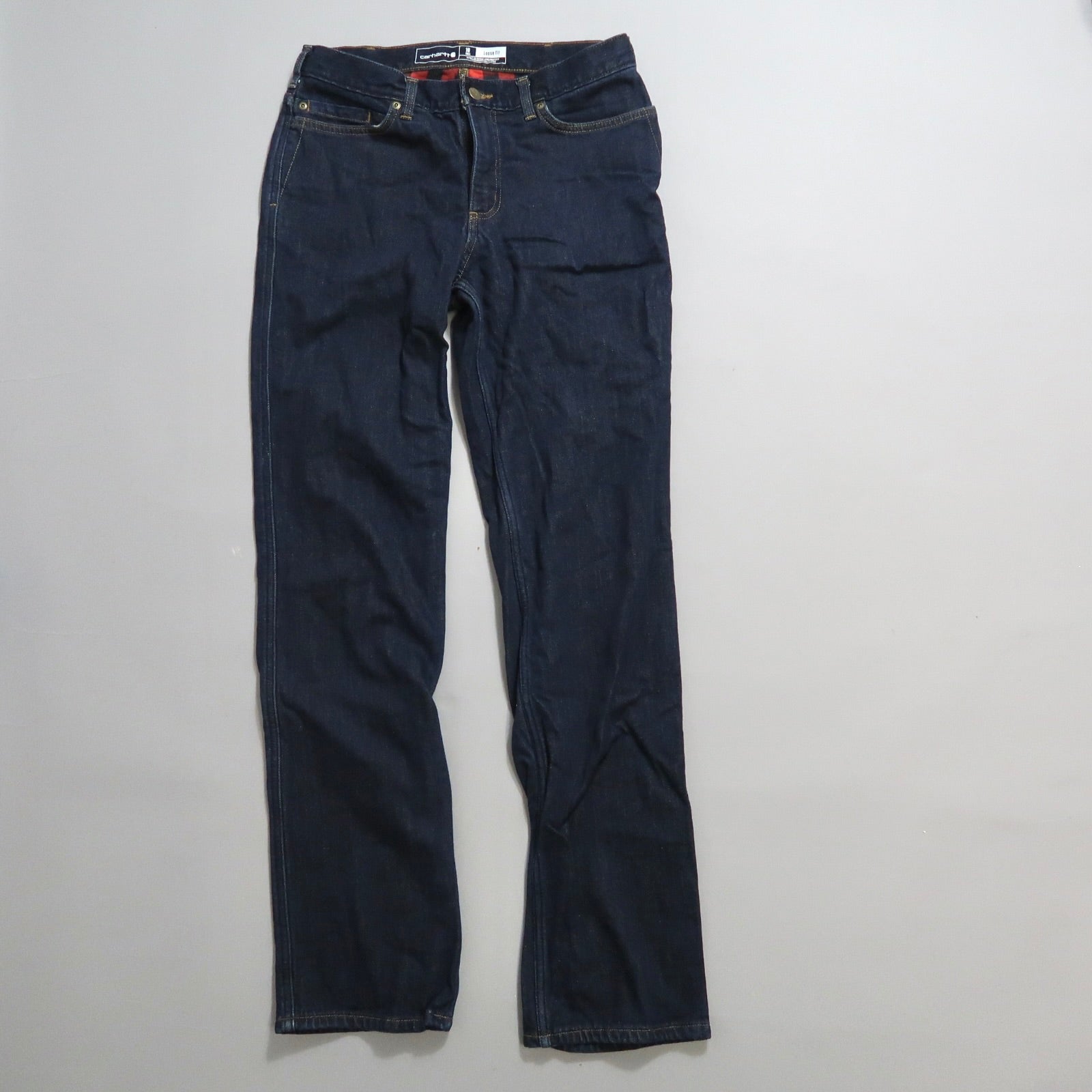 Dark blue jeans laid flat on a white surface.