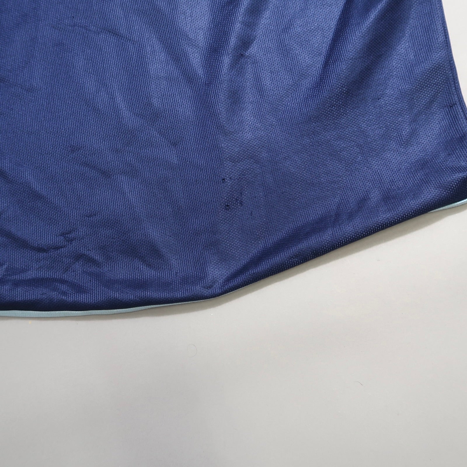 Close-up of blue fabric with slight wrinkles and texture.