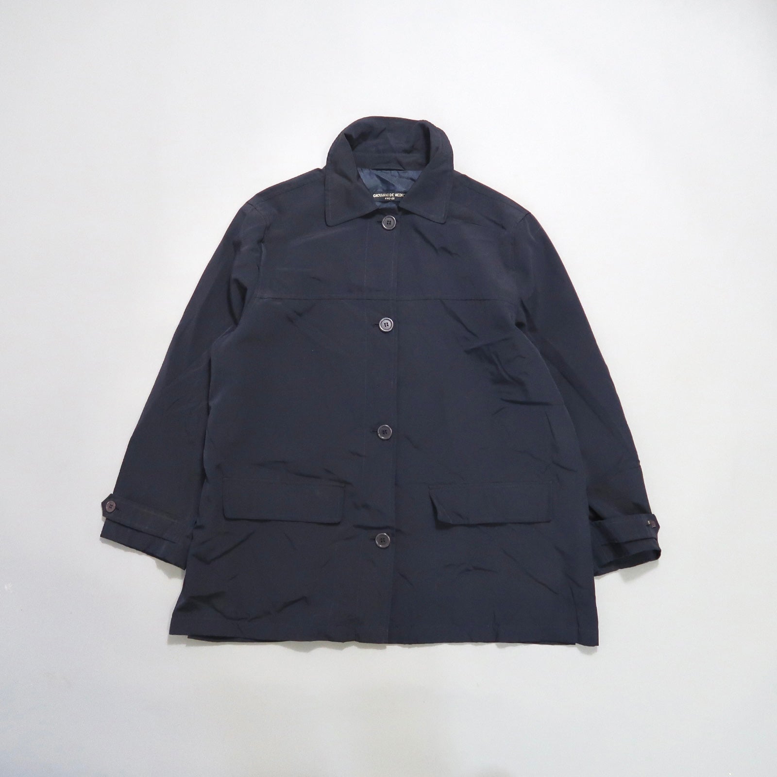Dark blue buttoned coat on a white background.