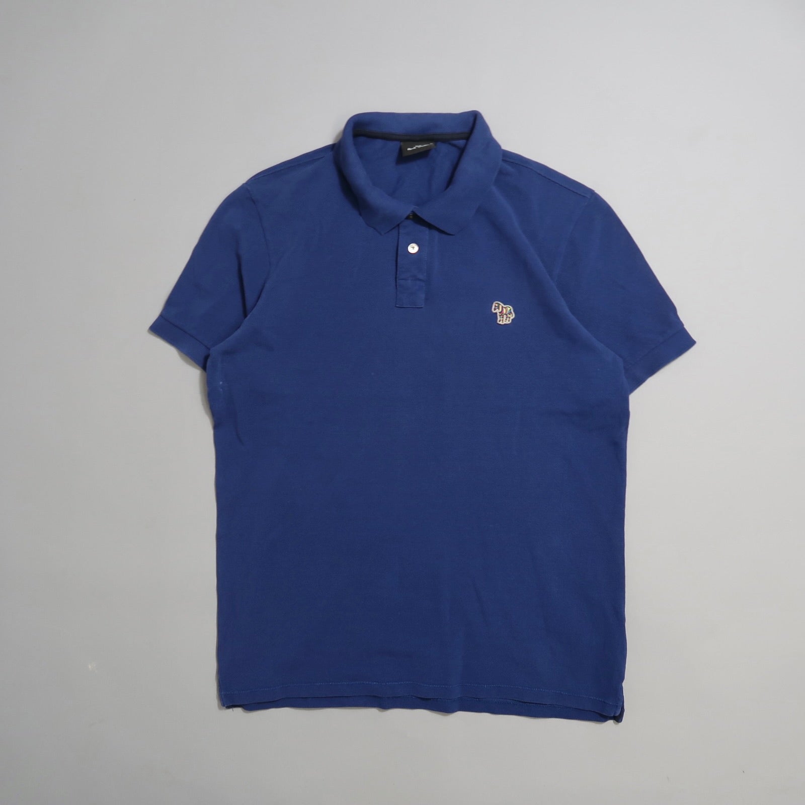 Blue polo shirt with a small embroidered logo on the chest.