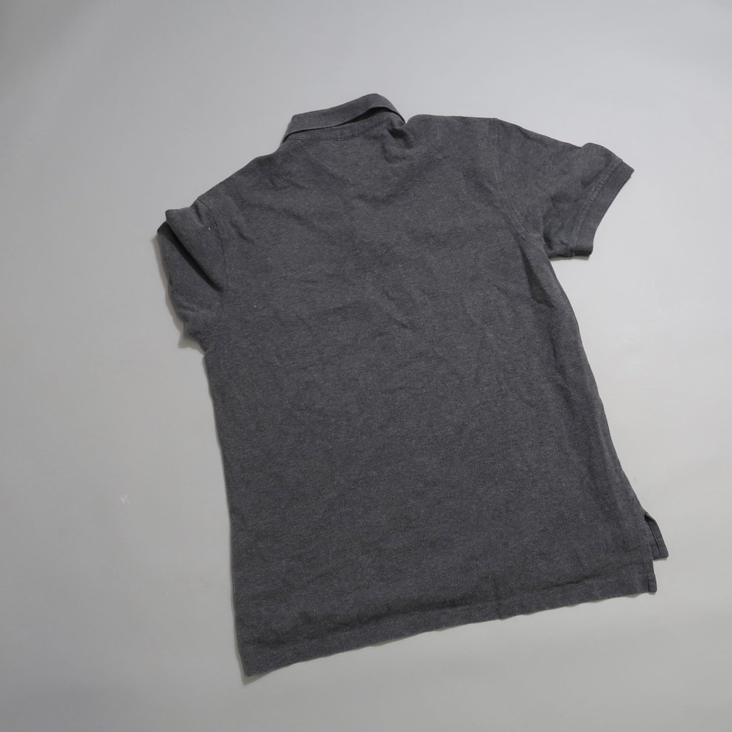 Gray polo shirt laid flat with the back side visible.