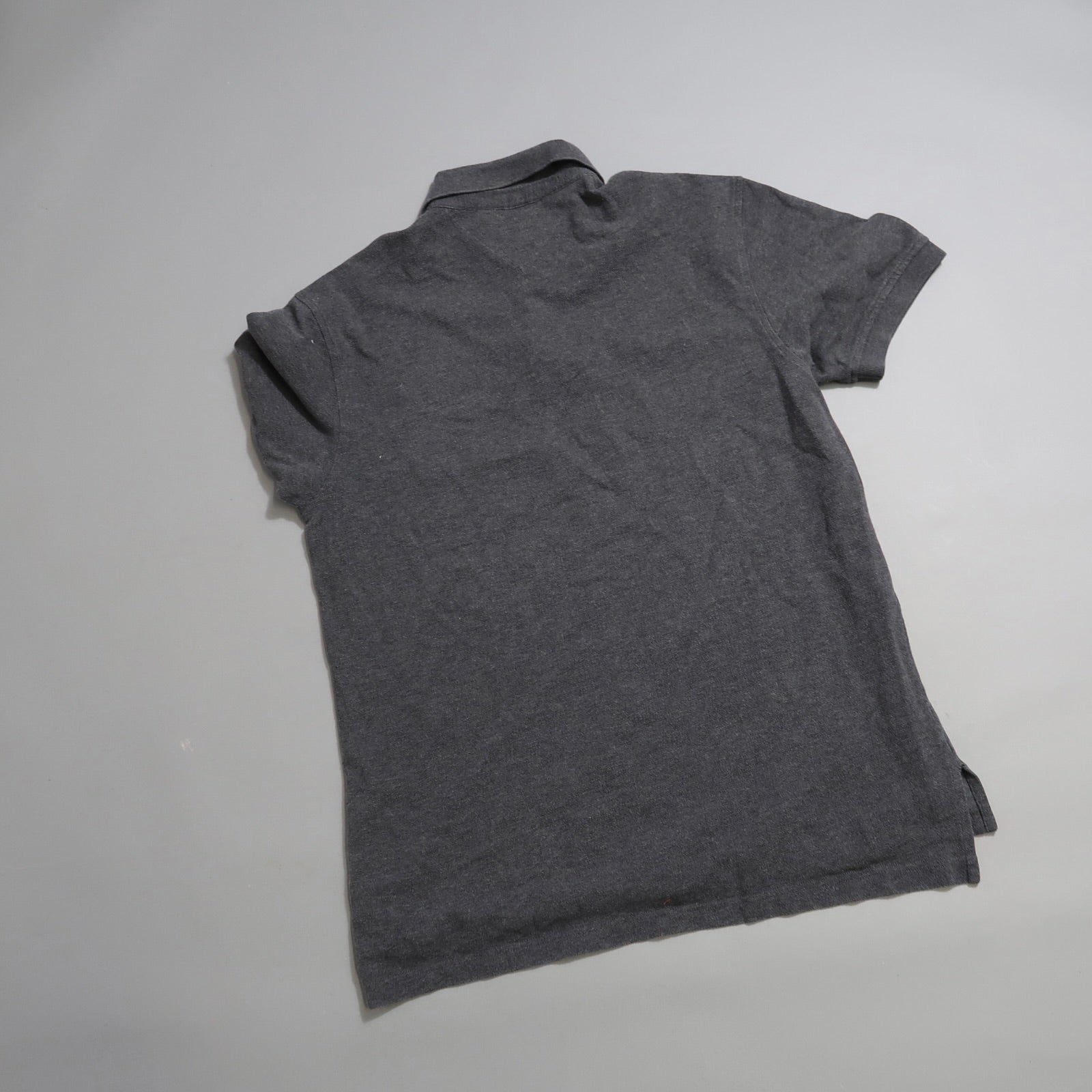 Gray polo shirt laid flat with the back side visible.