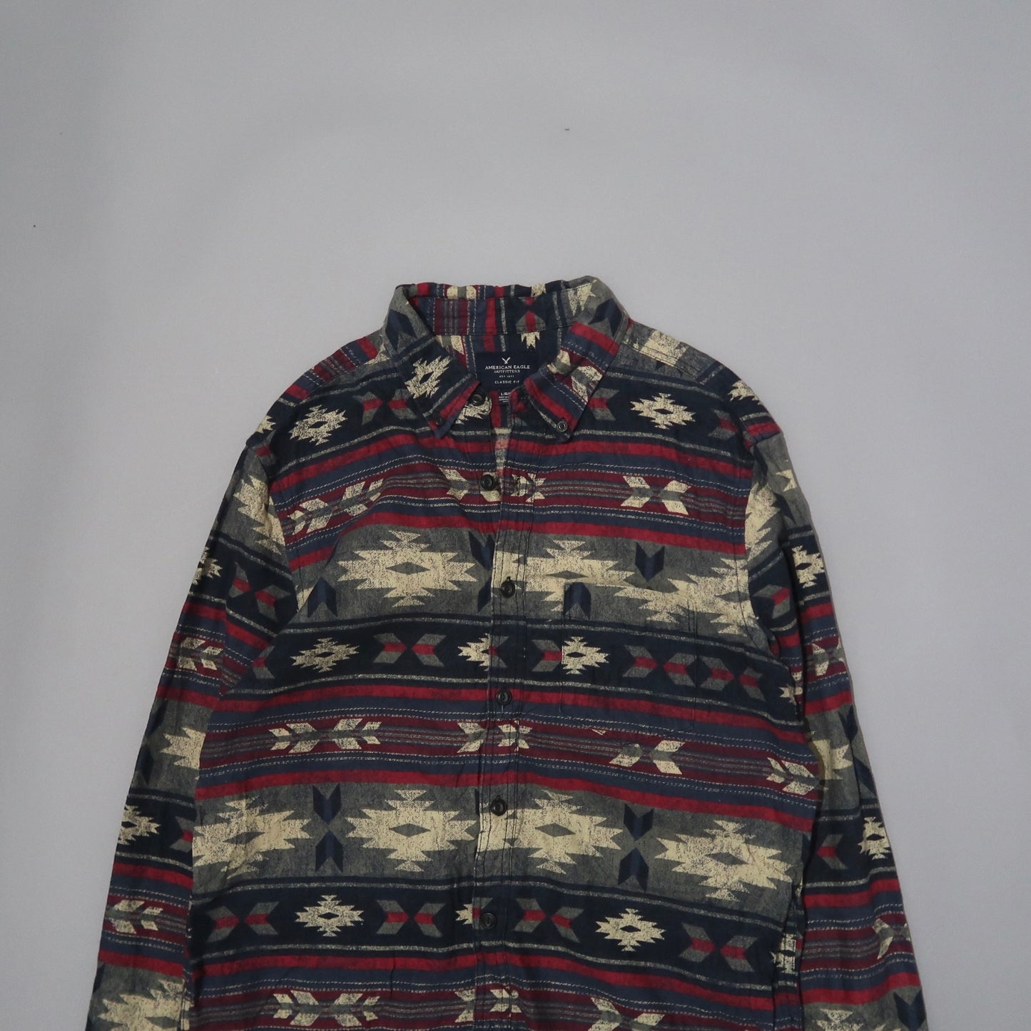 Patterned shirt with geometric designs on a plain background.