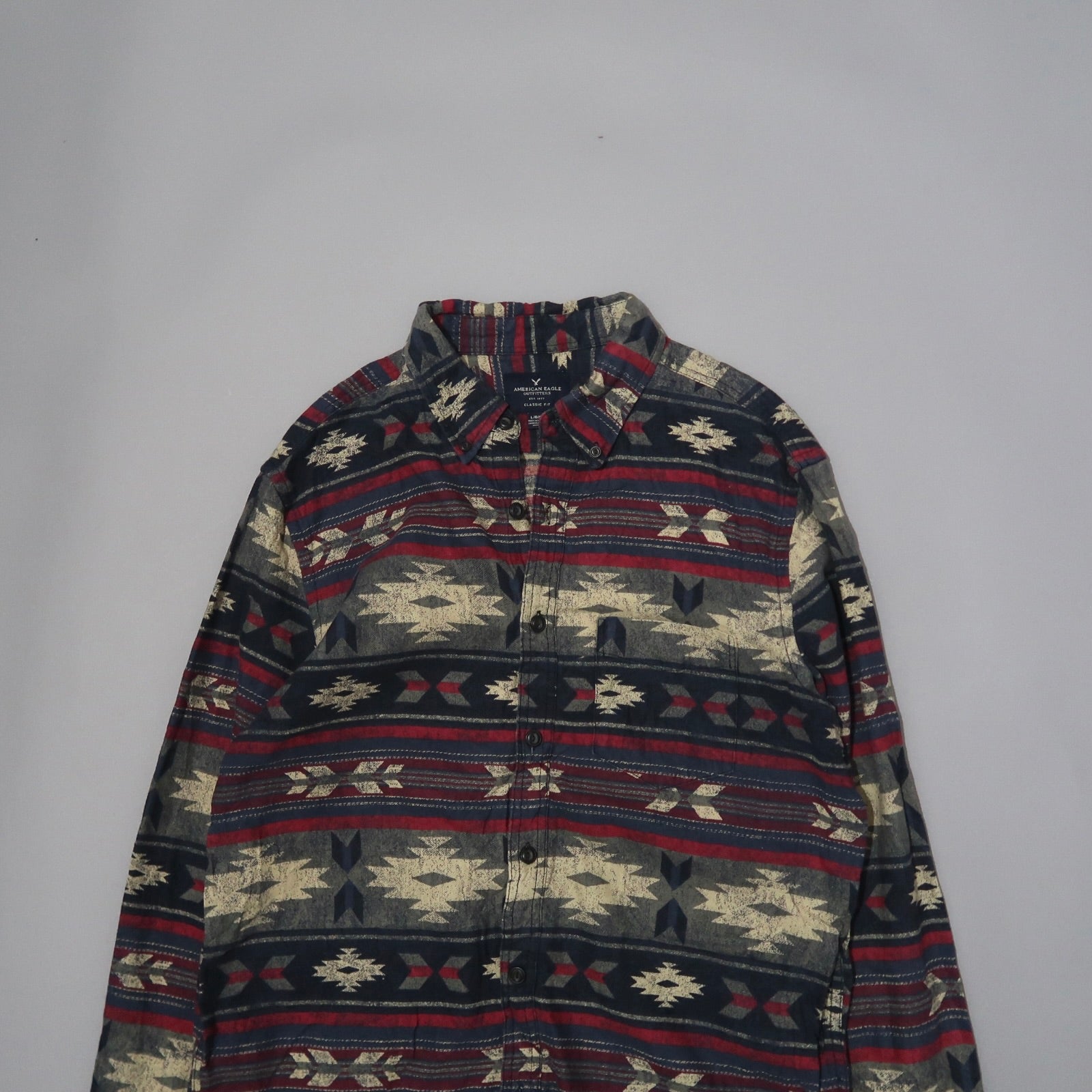 Patterned shirt with geometric designs on a plain background.