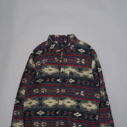 Patterned shirt with geometric designs on a plain background.
