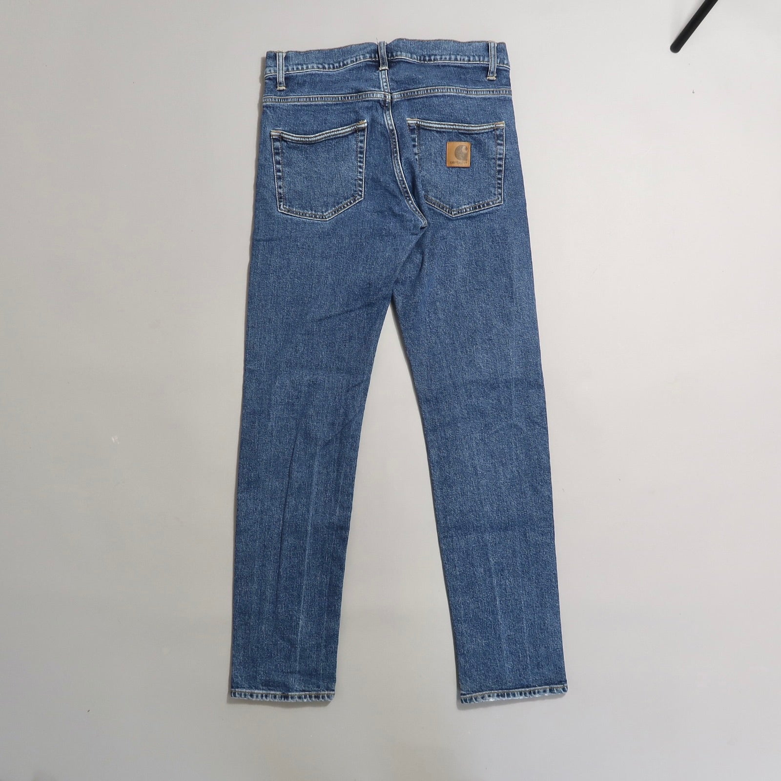 Blue jeans with a brown logo patch on the back pocket.