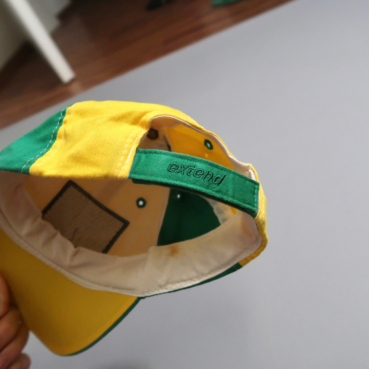 Yellow and green cap with adjustable strap labeled nullextend.null