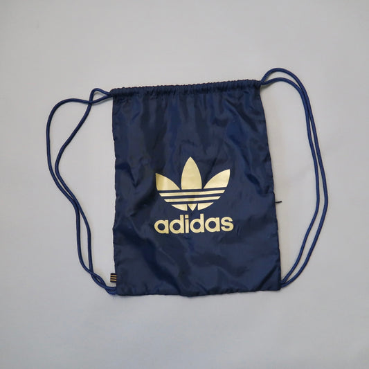 Blue Adidas drawstring bag with logo on a plain background.