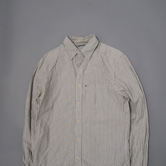 Beige and white striped button-up shirt on gray background.