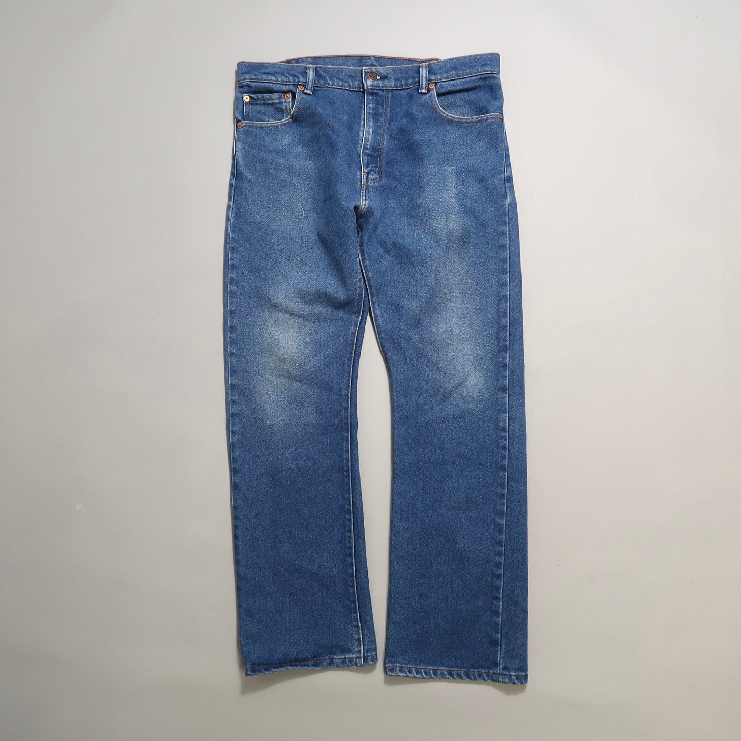 Blue denim jeans on a light grey background.
