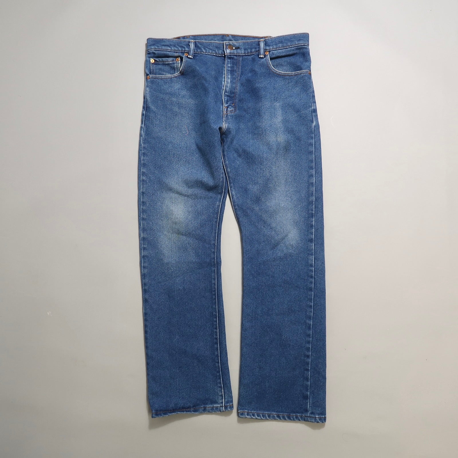 Blue denim jeans on a light grey background.