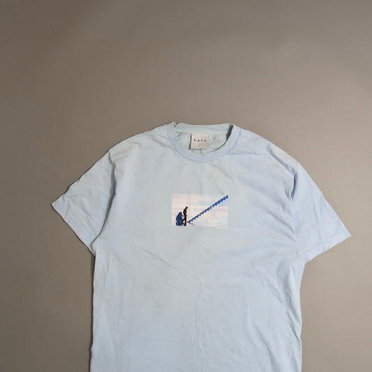 Light blue T-shirt with a printed image of a person climbing stairs.