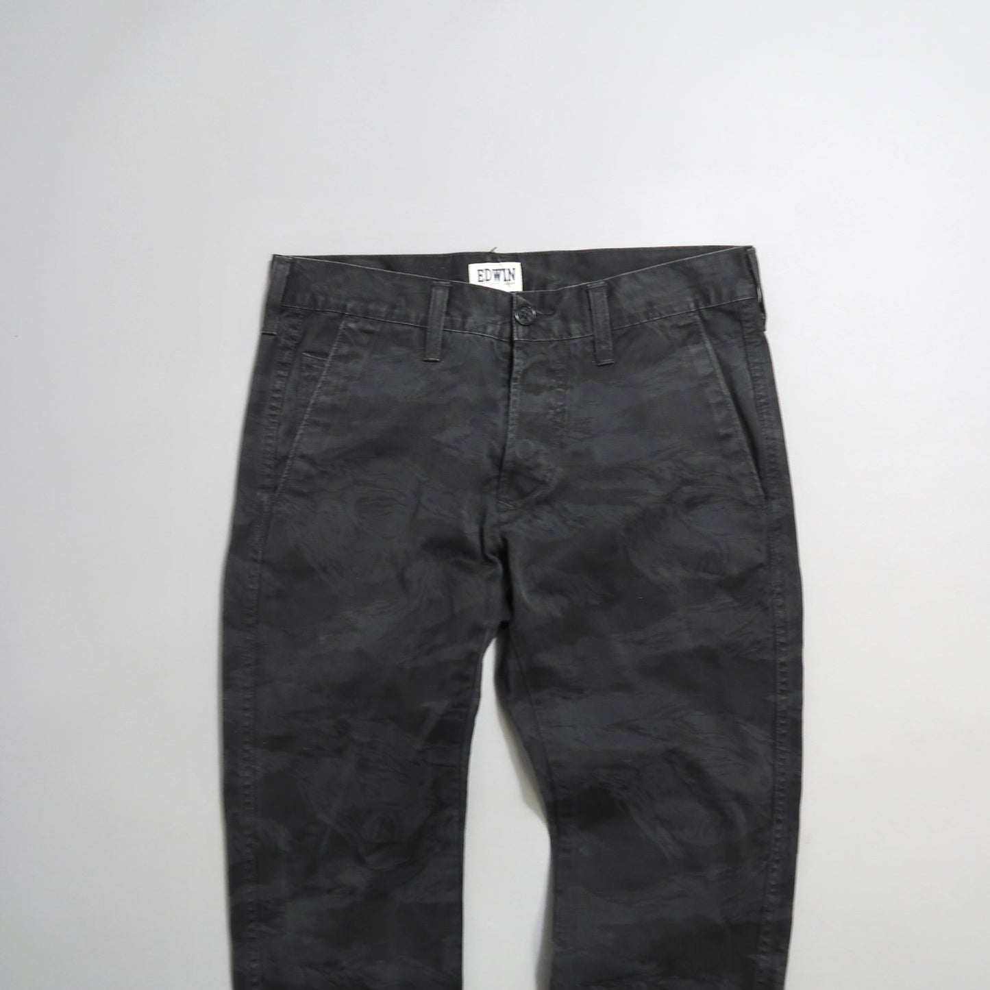 Dark gray patterned trousers on a white background.