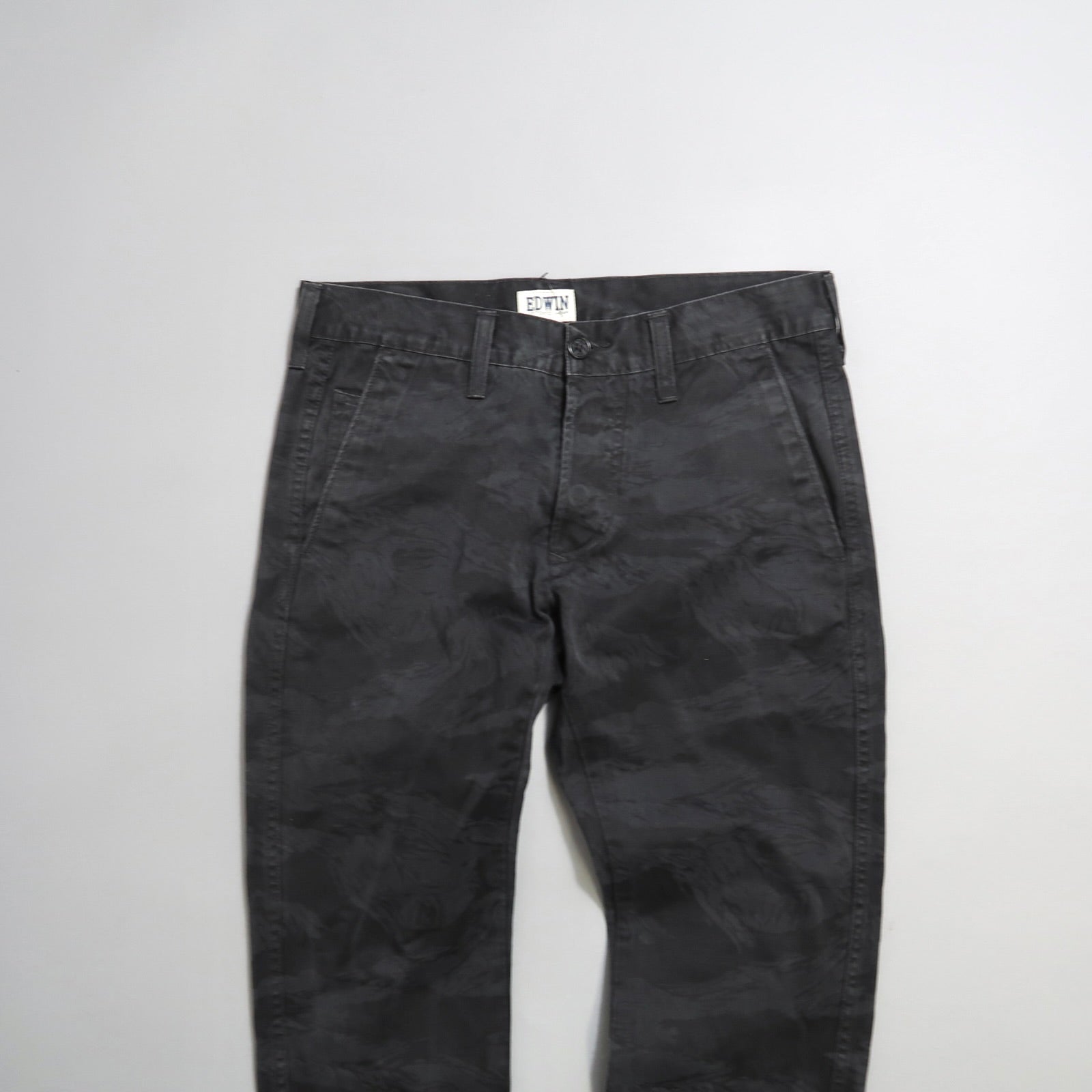 Dark gray patterned trousers on a white background.