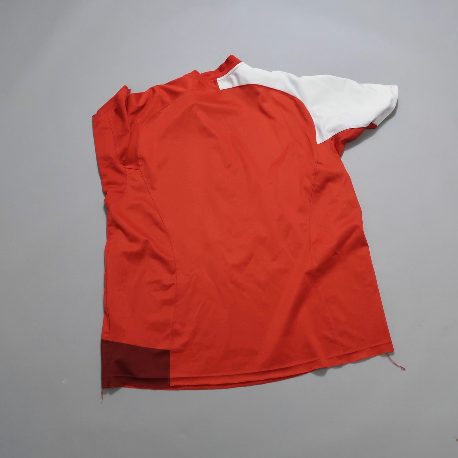 Red and white short-sleeved shirt on a gray background.