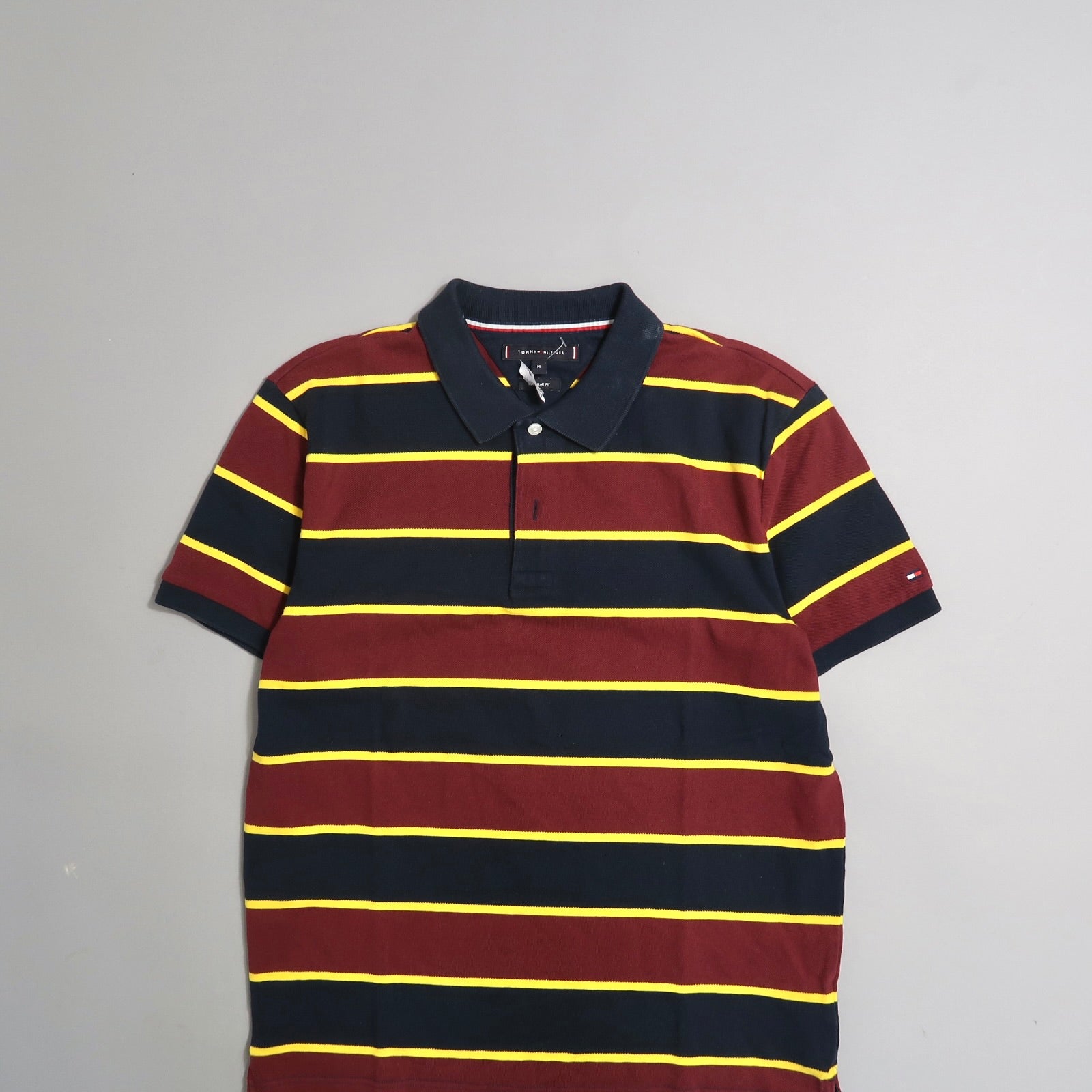 Striped navy and burgundy polo shirt with yellow lines.