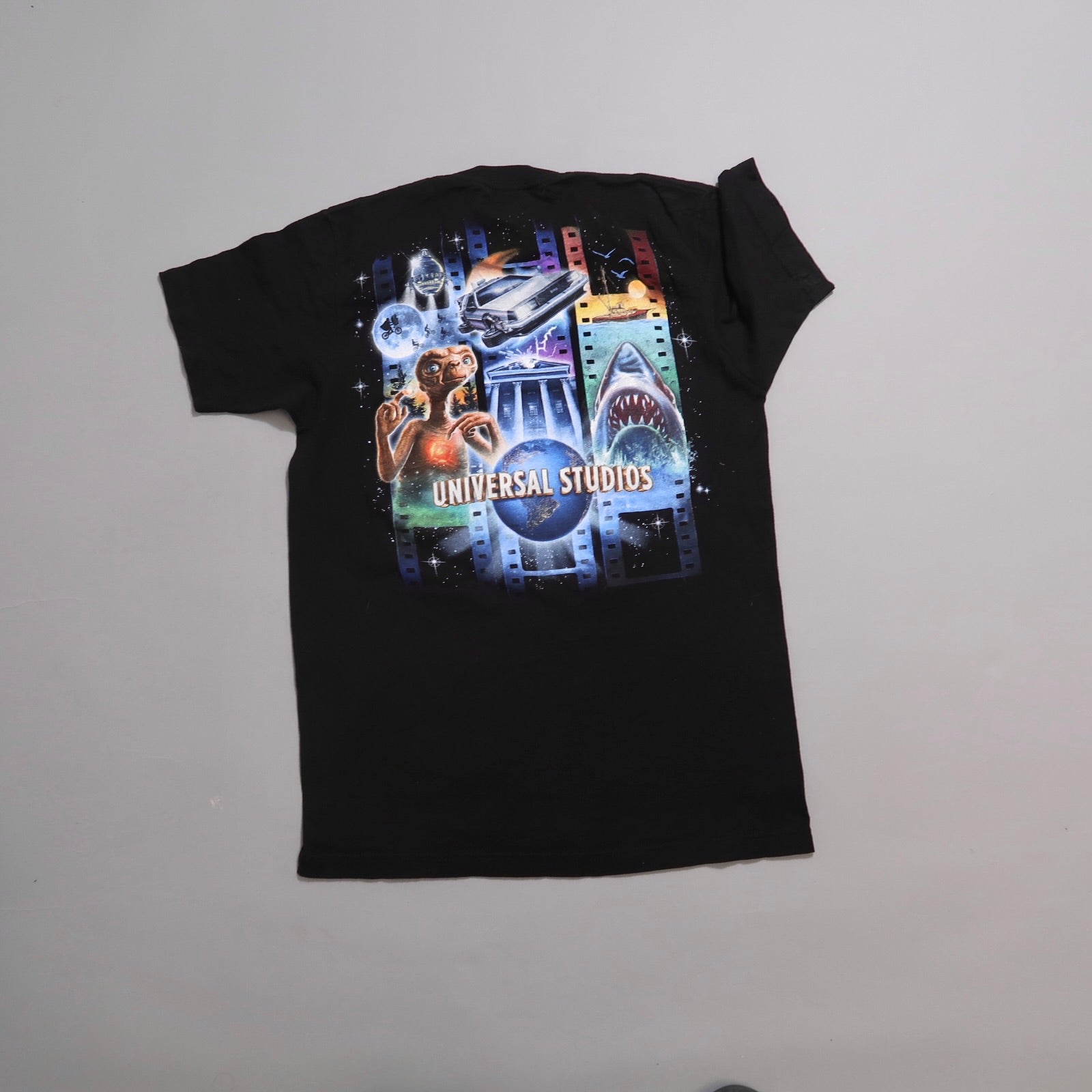 Black t-shirt with Universal Studios-themed graphics.