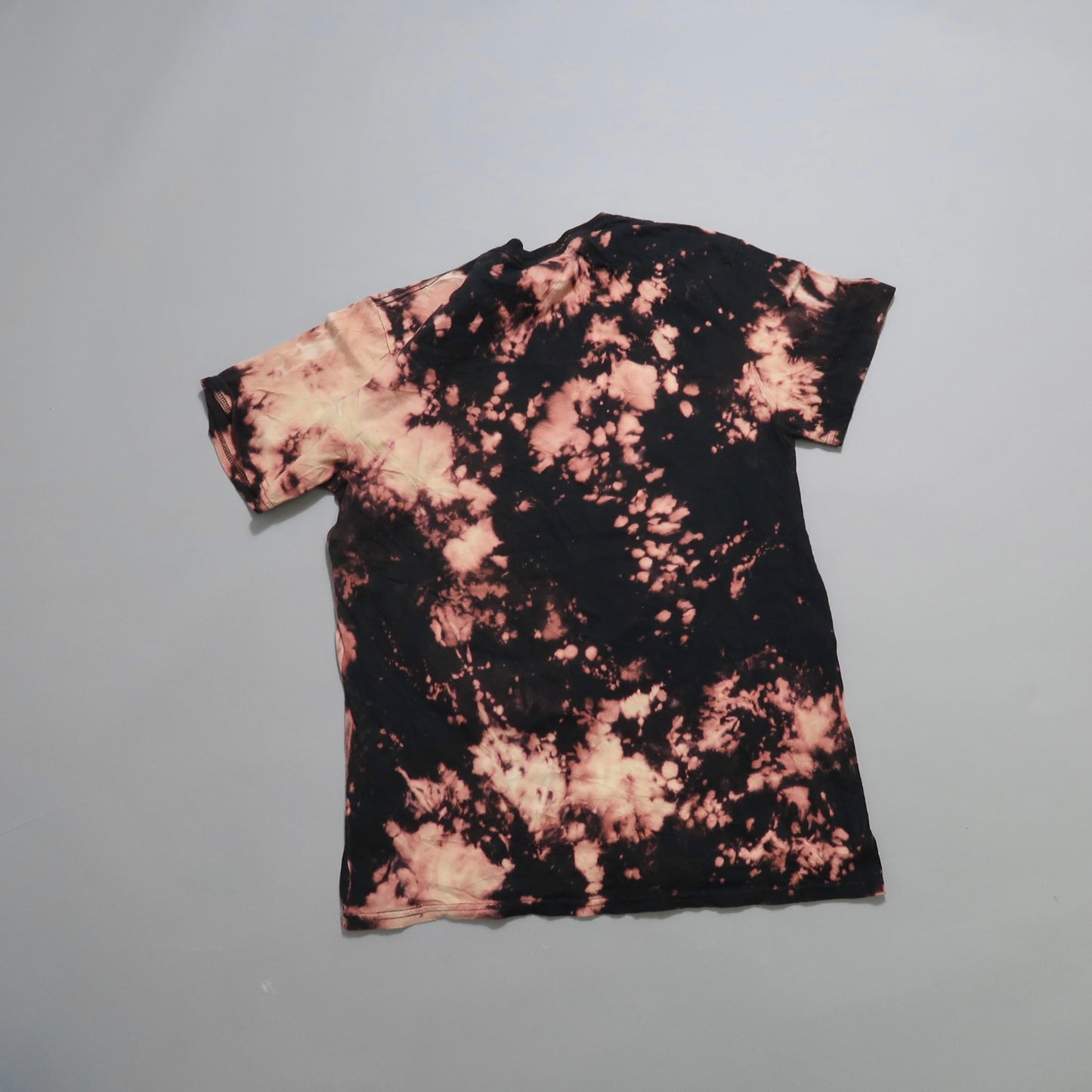 Black and pink tie-dye T-shirt on a gray background.