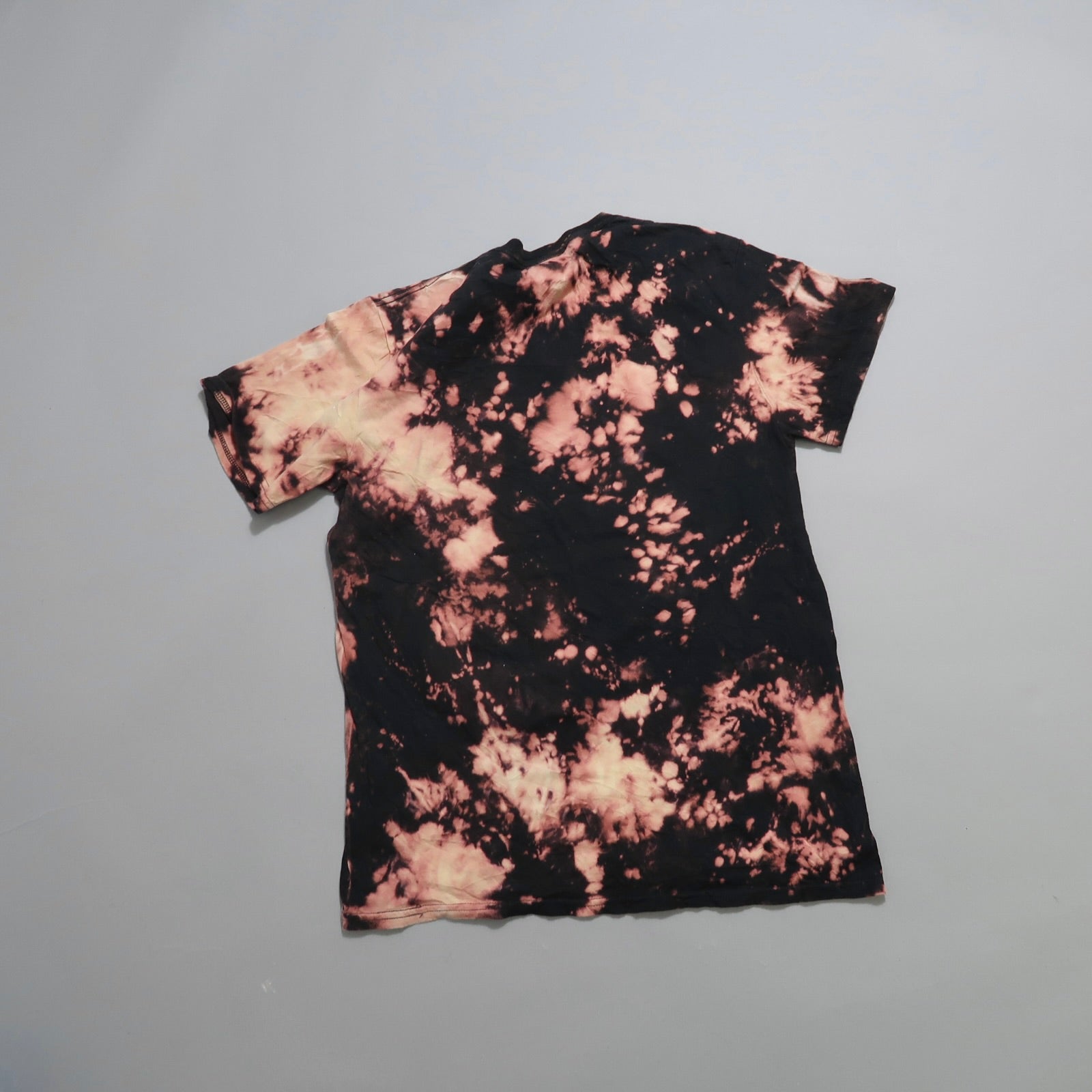 Black and pink tie-dye T-shirt on a gray background.