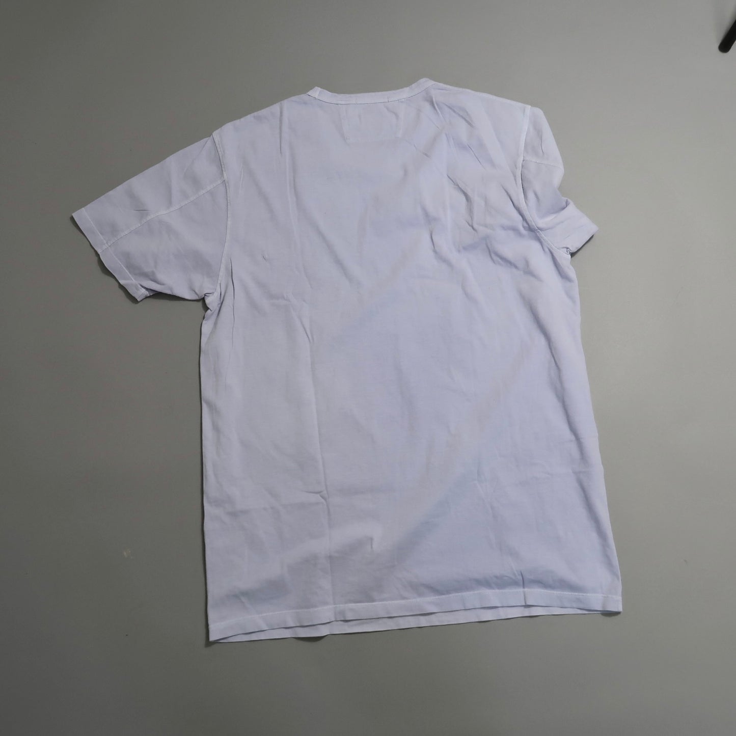 White T-shirt laid flat on a gray background, back view.