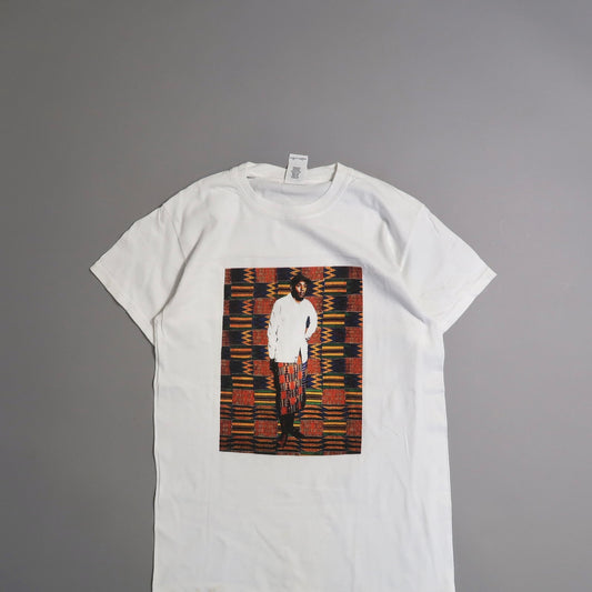 White T-shirt with colorful print of person in front of patterned backdrop.