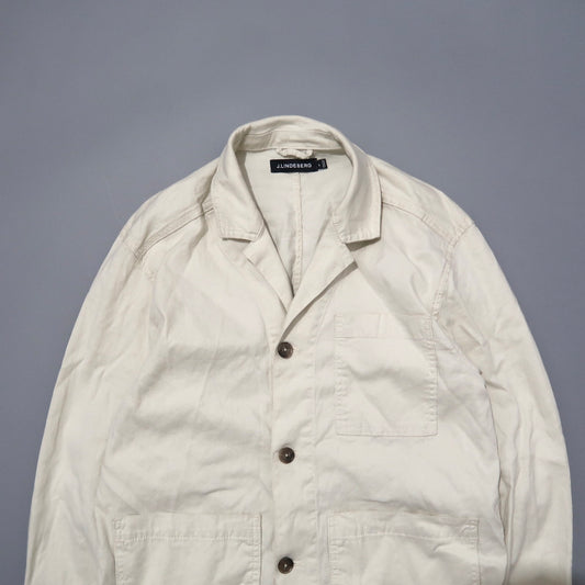 Cream-colored button-up jacket with chest pocket against gray background.