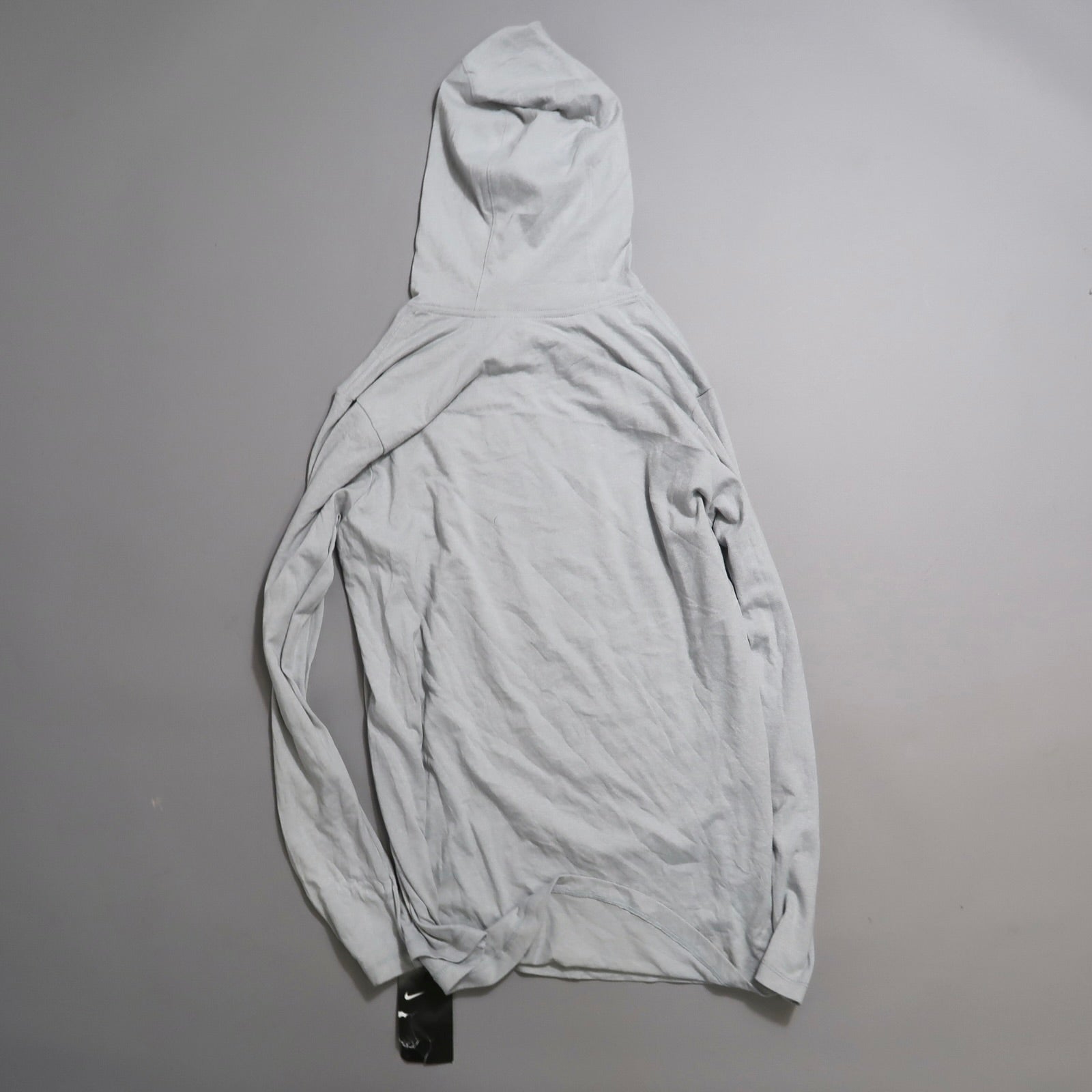 Gray hoodie laid flat on a gray surface, viewed from the back.