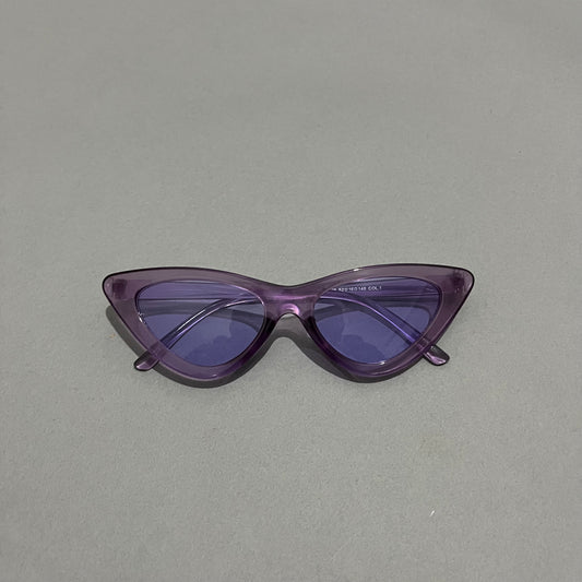 Purple cat-eye sunglasses on a plain gray background.