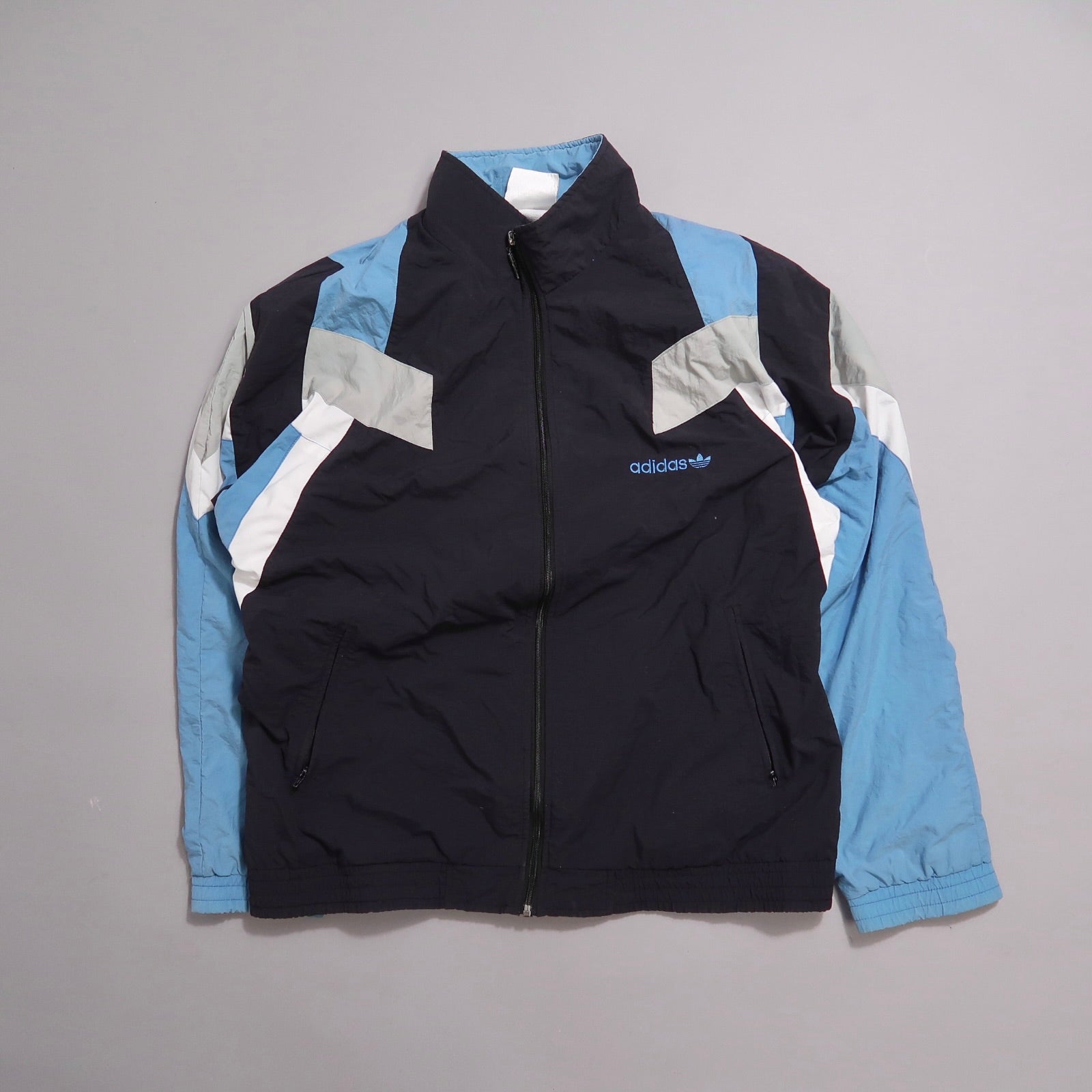 Blue and black Adidas track jacket with geometric design.